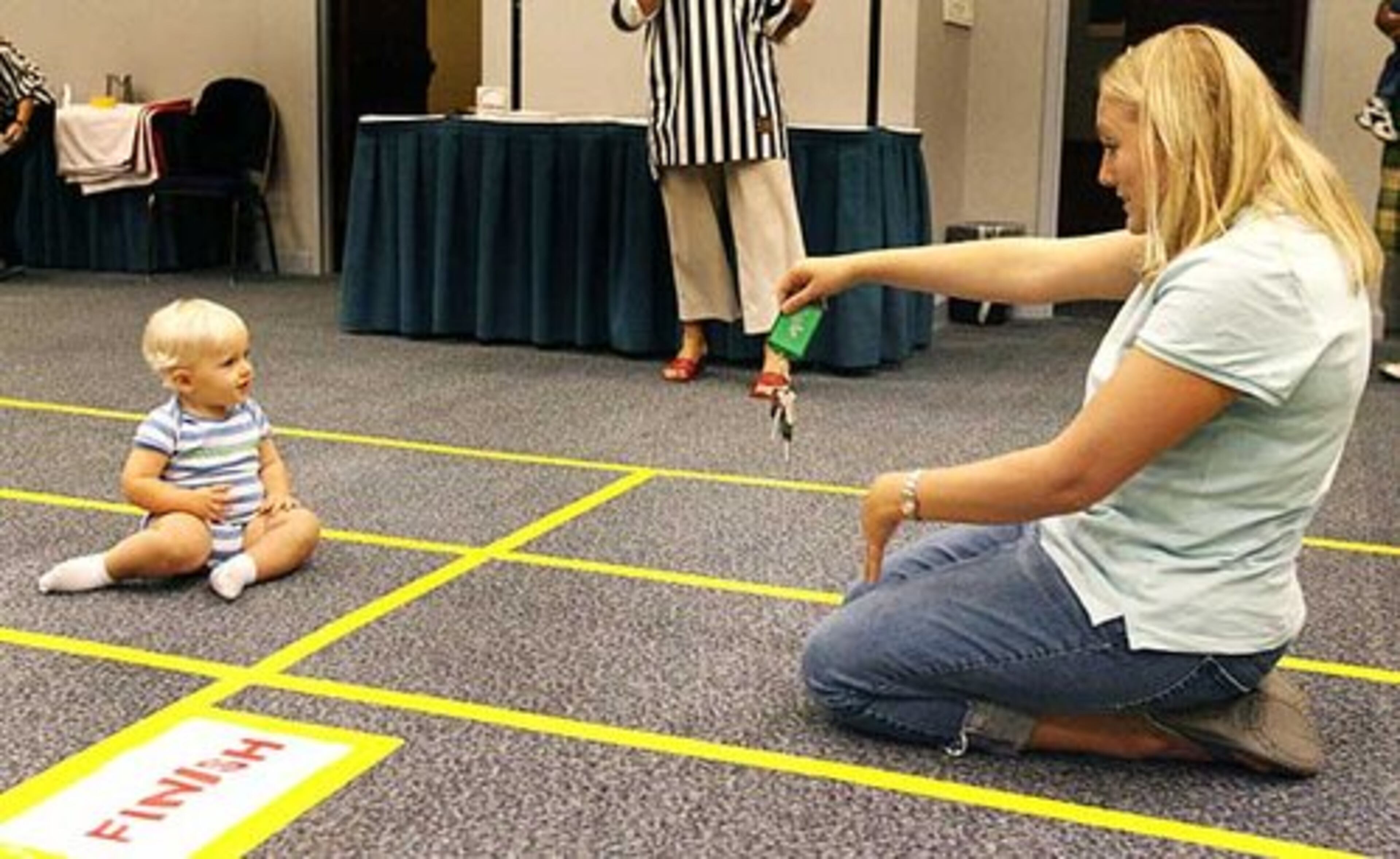 Rene Grant of Griffin gives encouragement to 12-month-old Isaac, who was first in his heat. More races will be held this weekend at the Babies 'R' Us Baby Derby at the 11th annual American Baby Faire Atlanta.