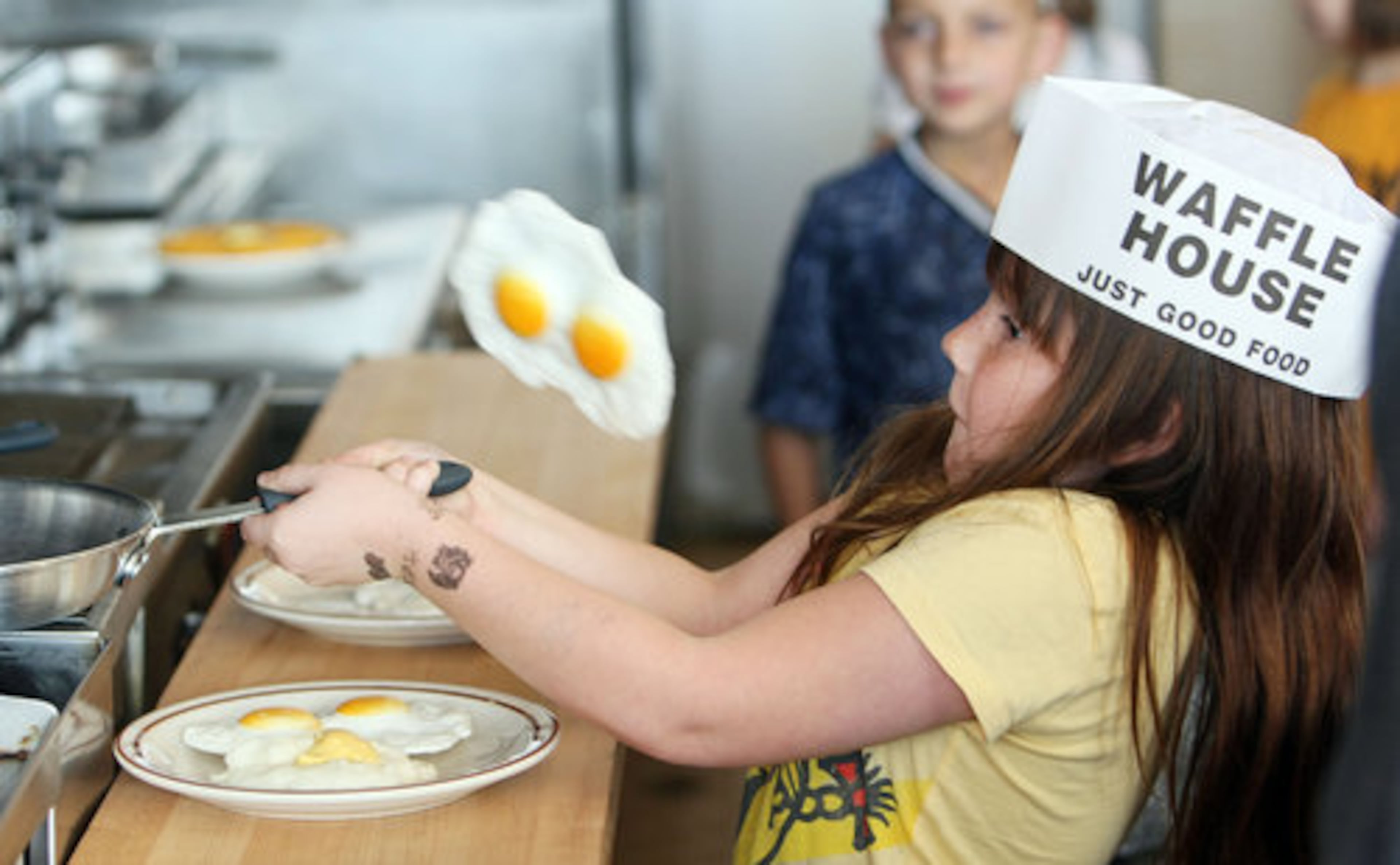 Arwen Williams, 8, tries her hand at the grill, flipping a pair of plastic eggs.