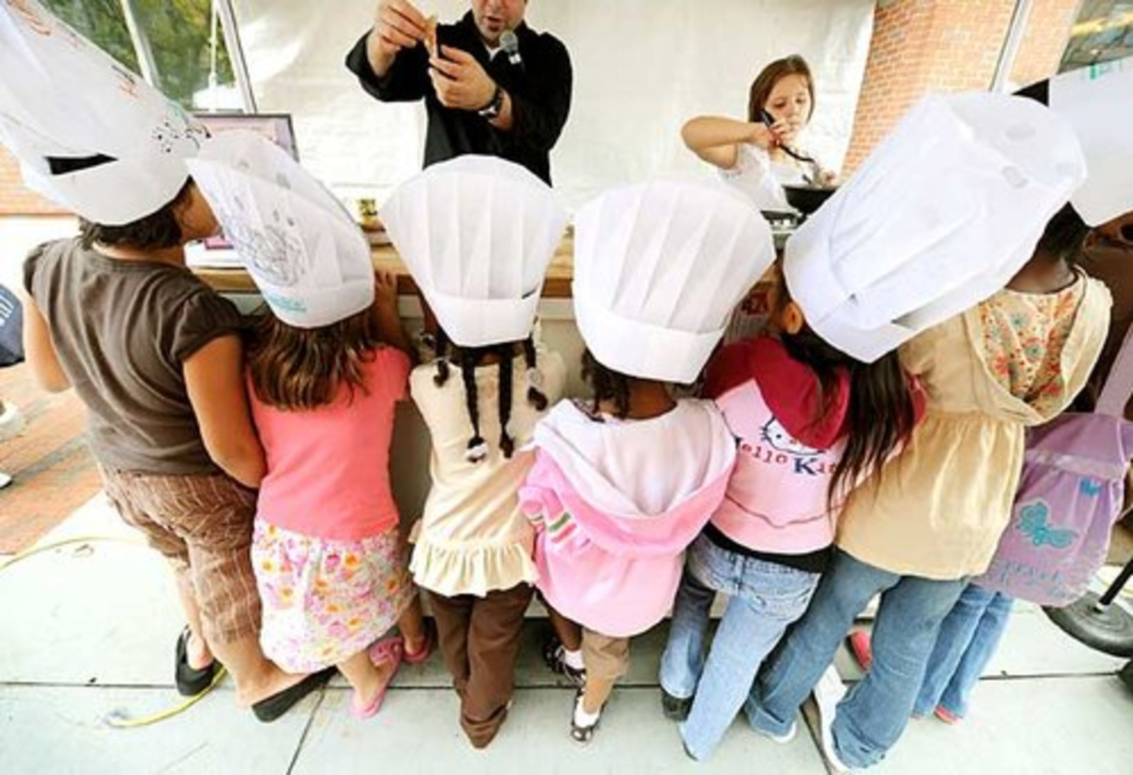 Young chefs check out a demonstration by Atlanta's Lizzie Marie (right), 8. She was assisted by George Duran (left) during Taste of Atlanta. Lizzie gave a demonstration of Green Eggs and Ham, on Kid's Avenue, an area of the festival showcasing tastes for little kids and big kids alike.