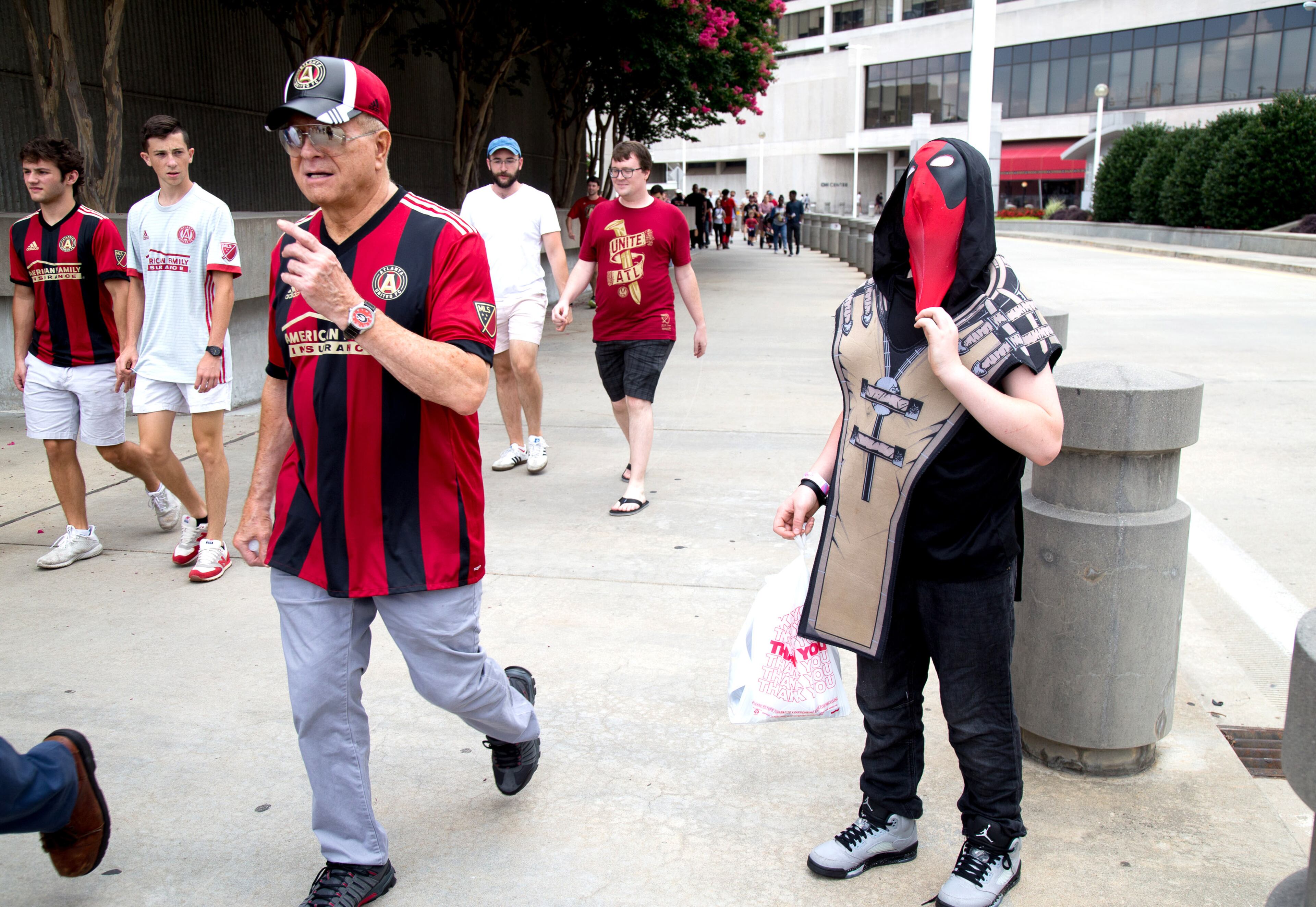 T.J. Adkisson, 13, adjusts his Deadpool costume mask as Atlanta United FC fans head to the game Sunday near the CNN center July 15, 201. STEVE SCHAEFER / SPECIAL TO THE AJC