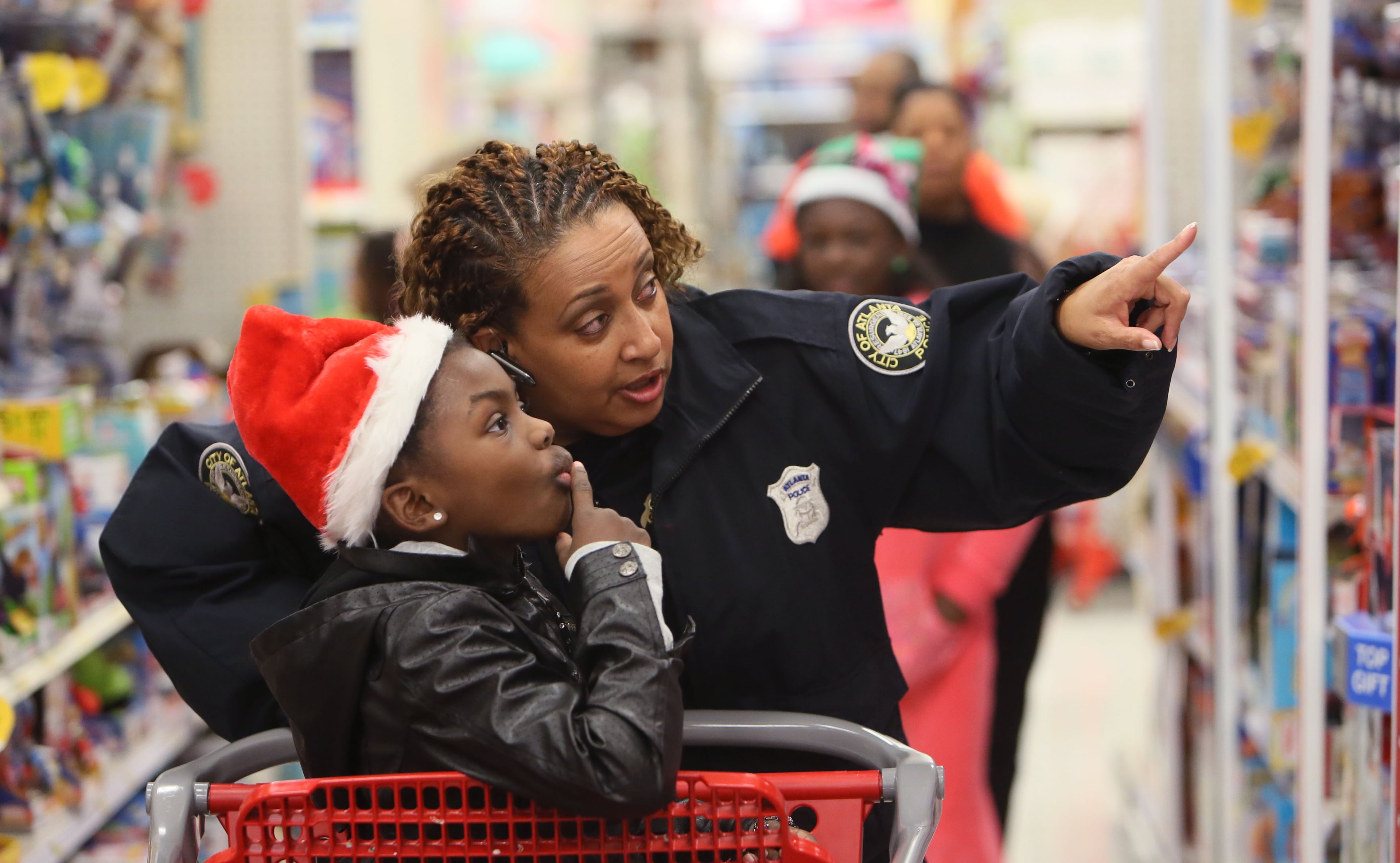 Elizabeth Smiley shops with her Santa Cop Shop host, Officer Kim Jones. She is one of the children of Officer Shawn A. Smiley, who was killed last year in a helicopter crash while search for a missing 9-year-old boy. The International Brotherhood of Police Officers hosted its annual “Santa Cop” Thursday. Atlanta Police Officers and children shopped for gifts at the Atlantic Station Target store after breakfast at the Hard Rock Cafe. Most of the children involved with this event would not have a Christmas if this event were not held.