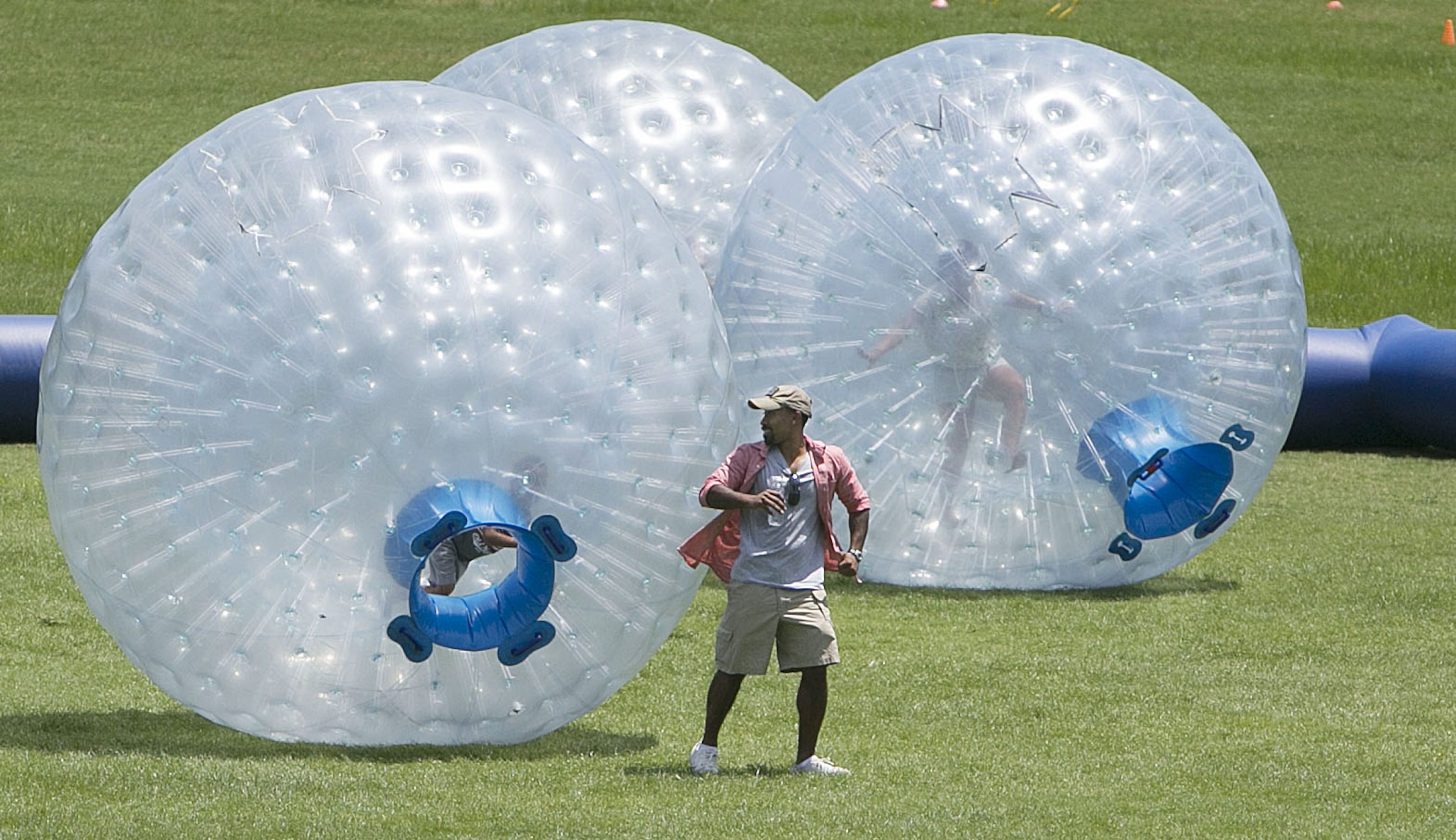 Johnta Austin ran away from a All-Star Active "Human Hamster Ball" inflated sphere (left) with his six-year-old son, Cash (age 6, both cq) inside. Local artisans and national classics presented their best products at the 4th Annual Atlanta Ice Cream Festival at Piedmont Park in Atlanta on Saturday, July 26, 2014. There was a variety of health /wellness agencies, fitness routines, vendors, entertainment, bands and fun family activities. (Photo by Phil Skinner)