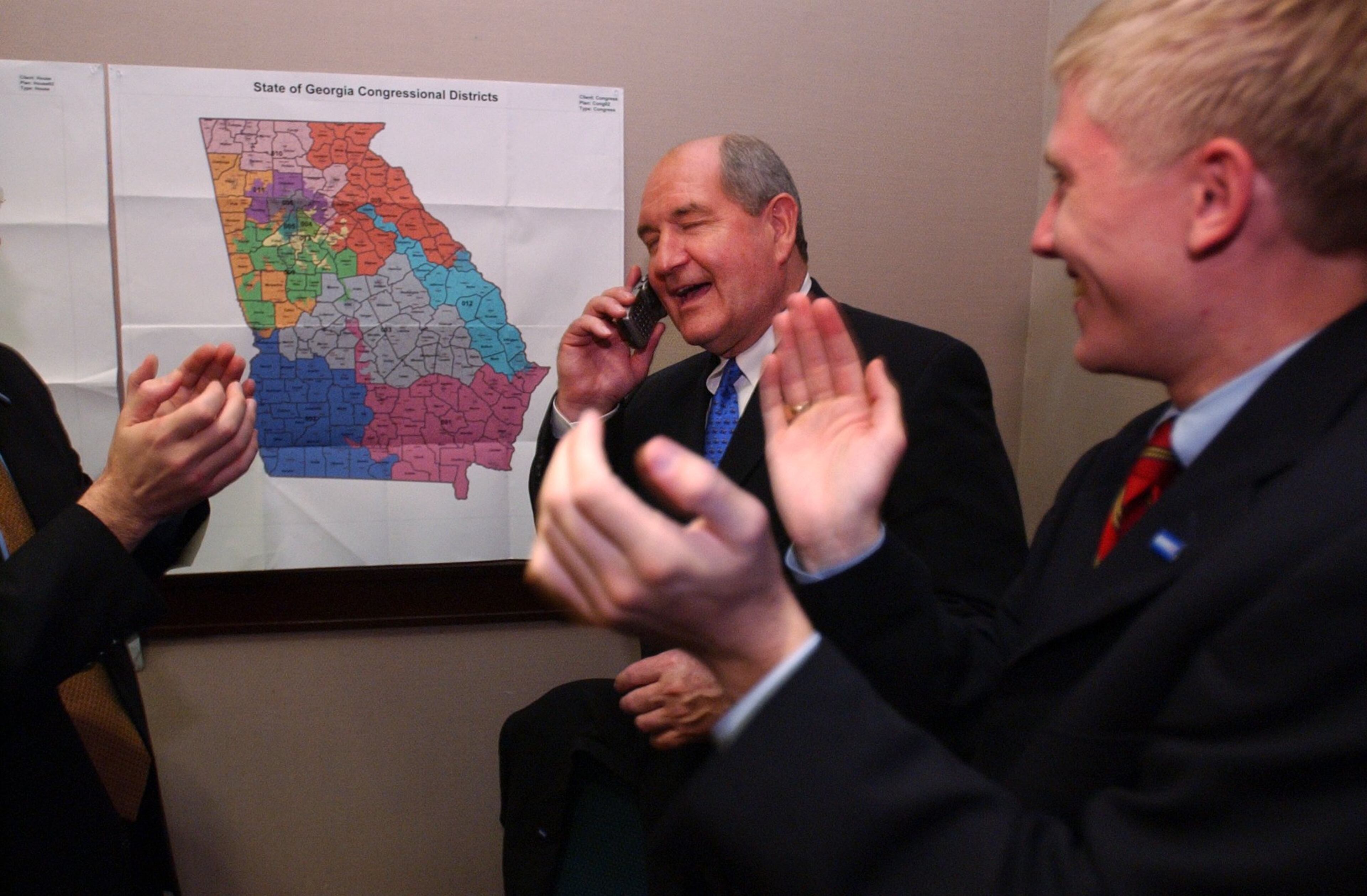 021105. ATLANTA. Sonny Perdue cq, Republican candidate for Governor, accepts congratulations on the phone from President Bush. Interestingly, the President's call to Perdue came before Barnes' call. This is taken in Perdue's war room. Right is campaign aide Nick Ayers cq. RICH ADDICKS/STAFF