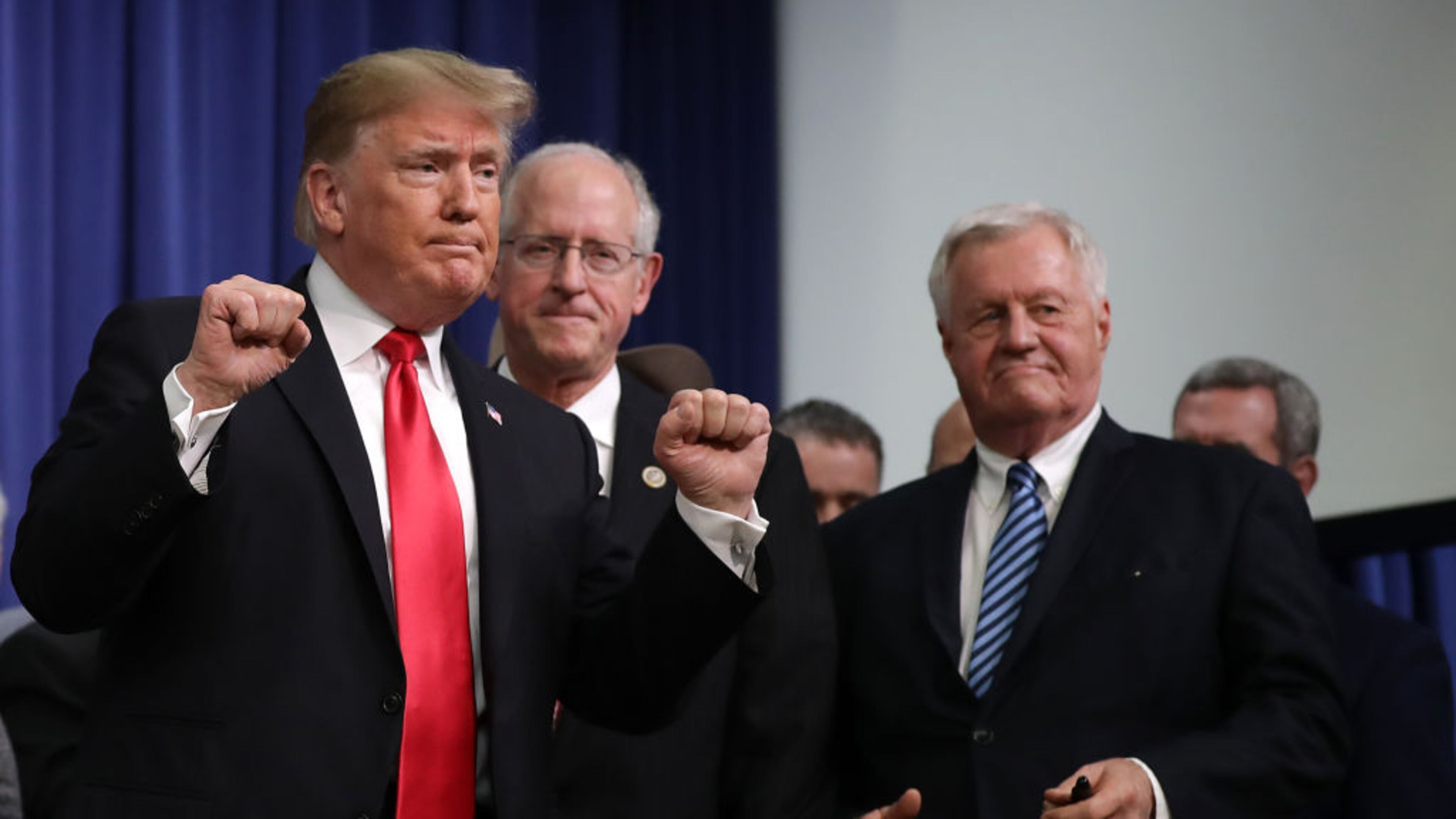 President Donald Trump pumps his fists after signing the the Agriculture Improvement Act during a ceremony with House Agriculture Committee Chairman Mike Conaway (R-TX) (2nd L) and ranking member Rep. Colin Peterson (D-MN) in the South Court Auditorium of the Eisenhower Executive Office Building December 20, 2018 in Washington, DC.