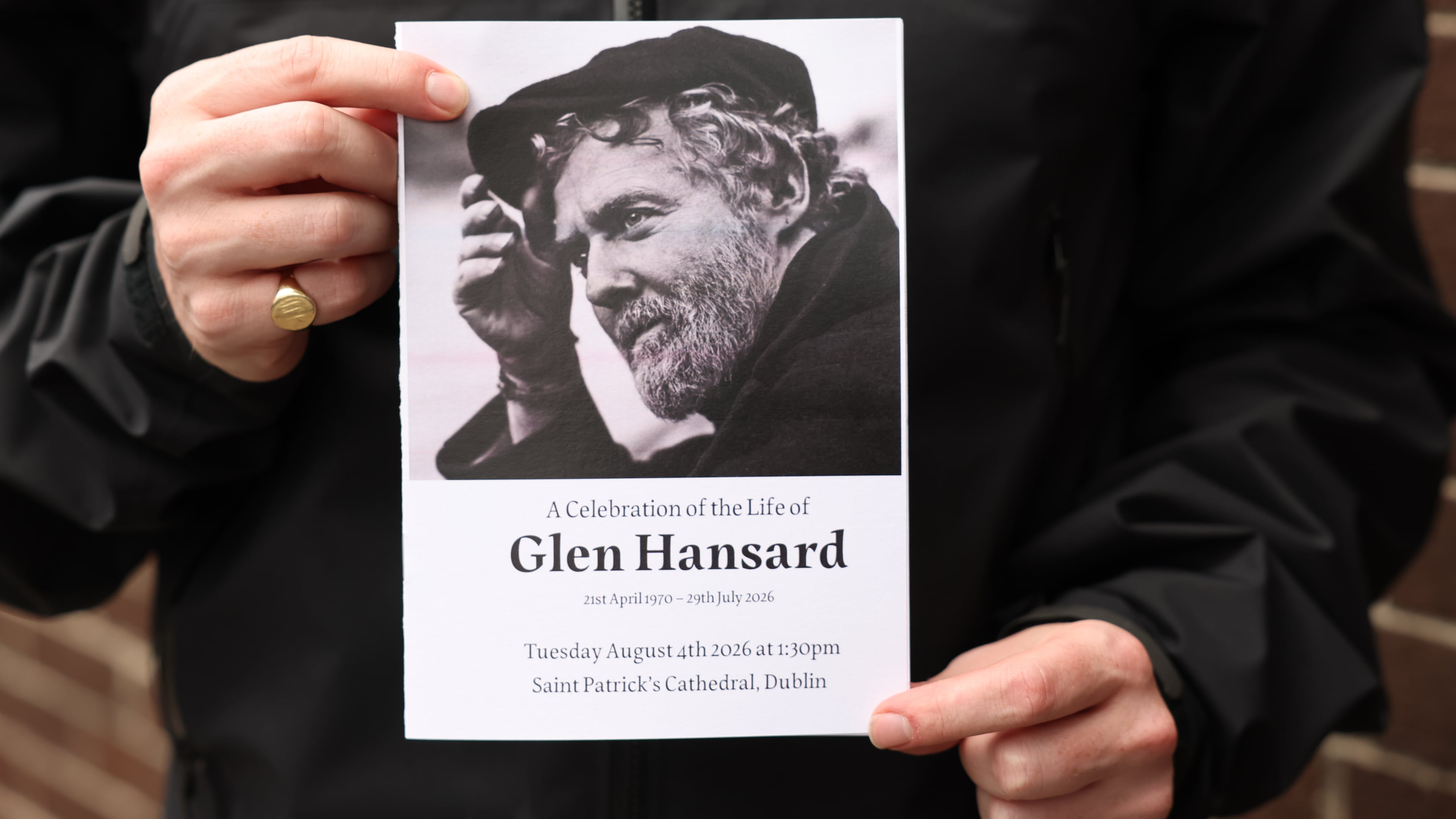 The Order of Service is held up ahead of the funeral of Glen Hansard at St Patrick's Cathedral in Dublin, Tuesday, Aug. 4, 2026. (Damien Eagers/PA via AP)