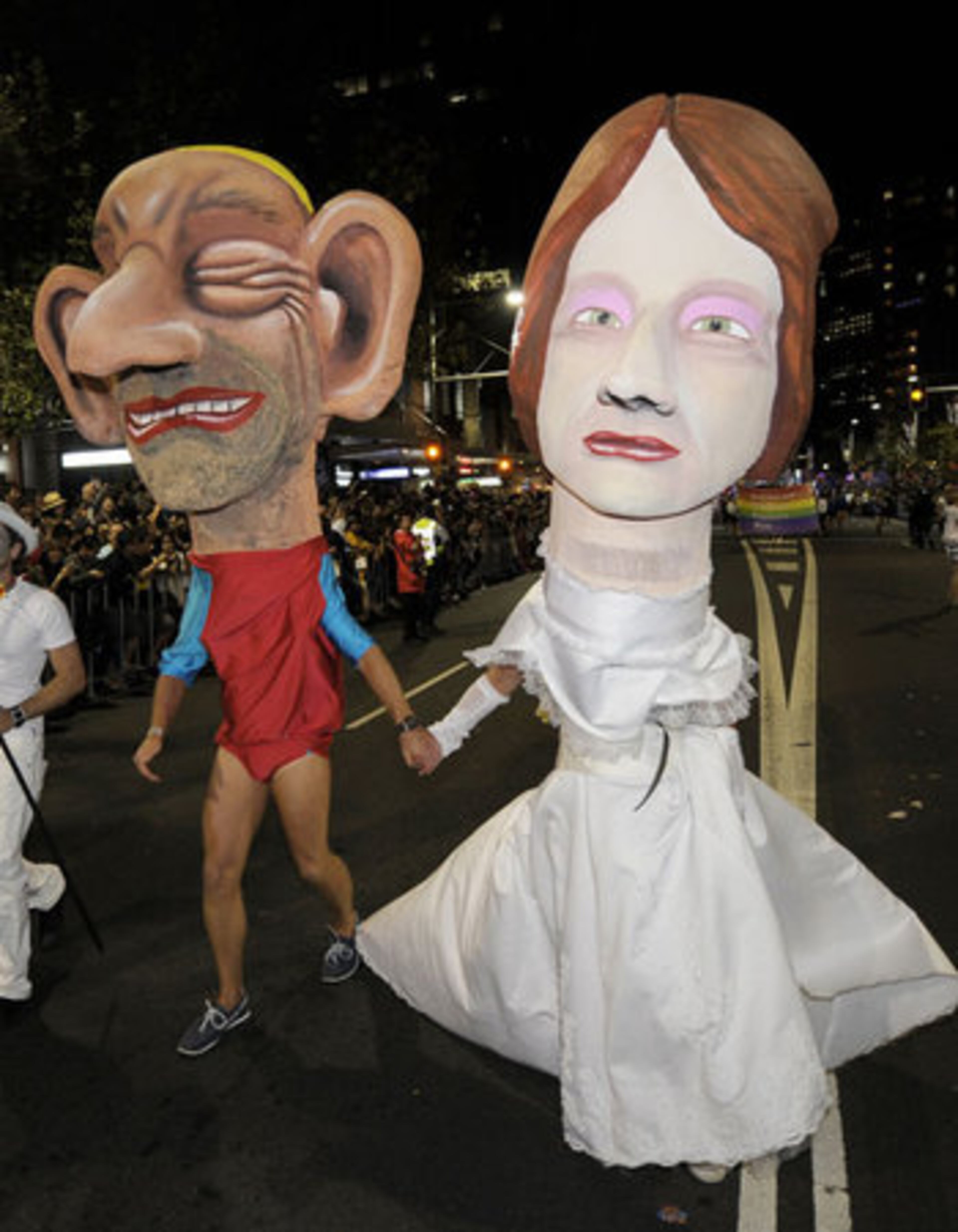 People wear caricature costumes of Australian Prime Minister Julia Gillard and opposition leader Tony Abbott in a parade during the celebrations.