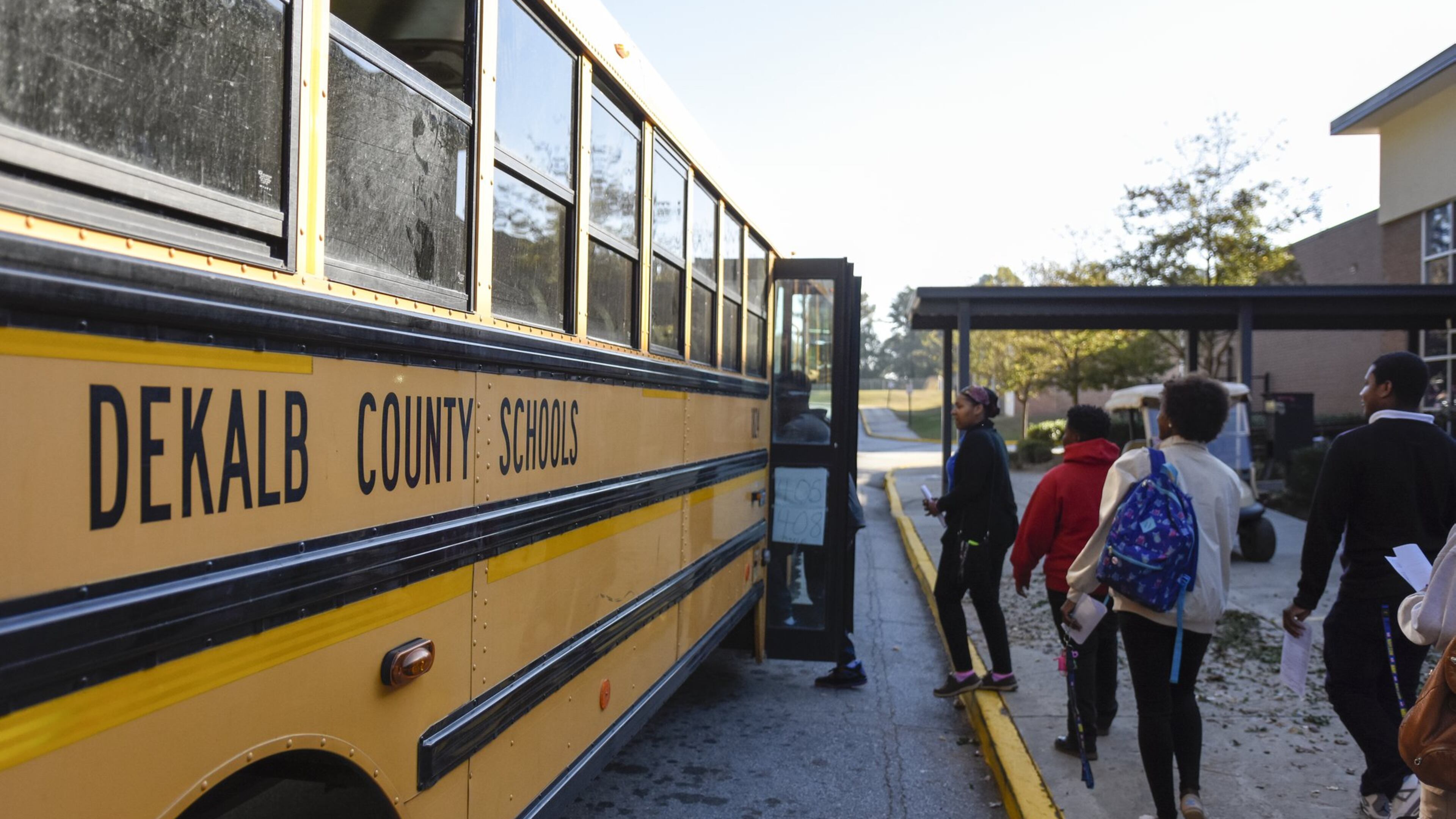 A group of Columbia High School seniors board a bus that will take them to a polling location. They went to early voting as a part of their coursework and to build familiarity with the electoral process. (DAVID BARNES / DAVID.BARNES@AJC.COM)