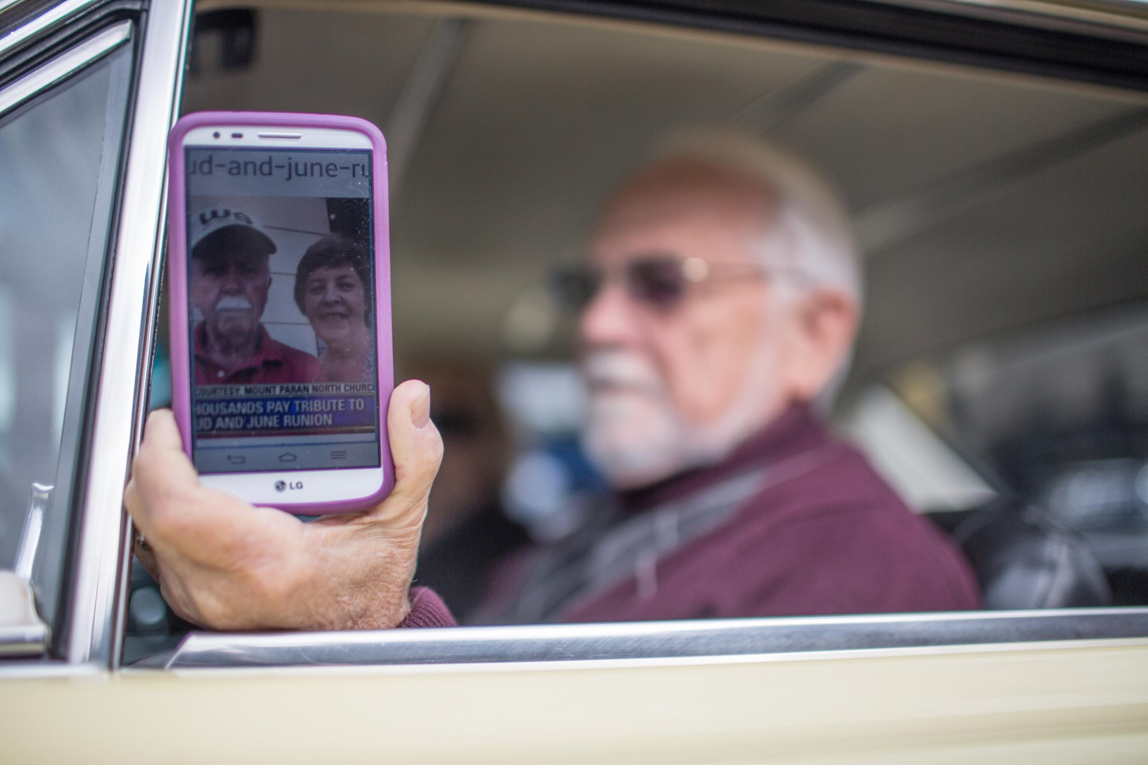 Wayne Williams, member of the classic car group, holds a cellphone with a photo of Bud and June Runion. (SPECIAL/BRANDEN CAMP)