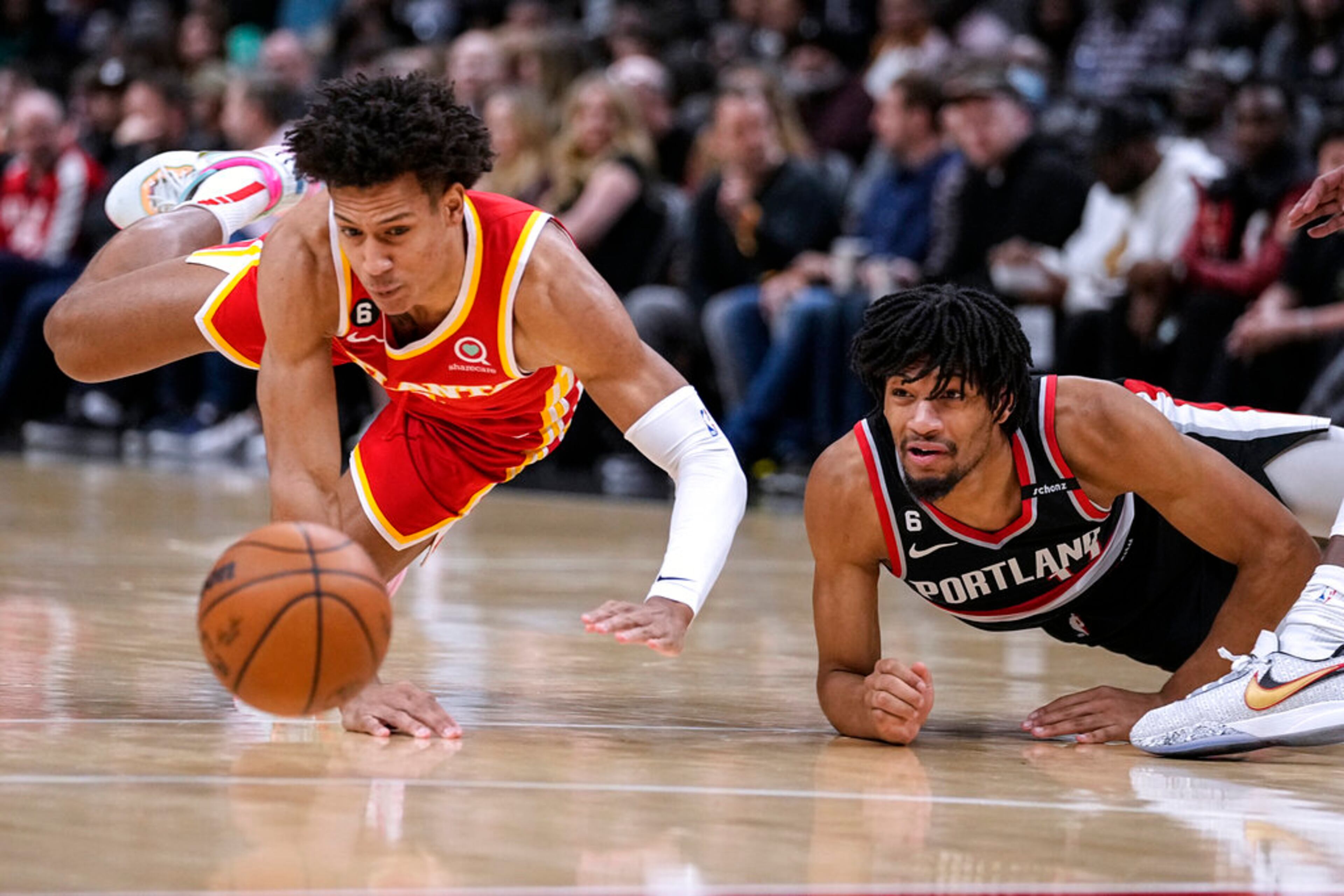 Atlanta Hawks forward Jalen Johnson, left, and Portland Trail Blazers guard Shaedon Sharpe scramble for the ball during the first half of an NBA basketball game Friday, March 3, 2023, in Atlanta. (AP Photo/John Bazemore)
