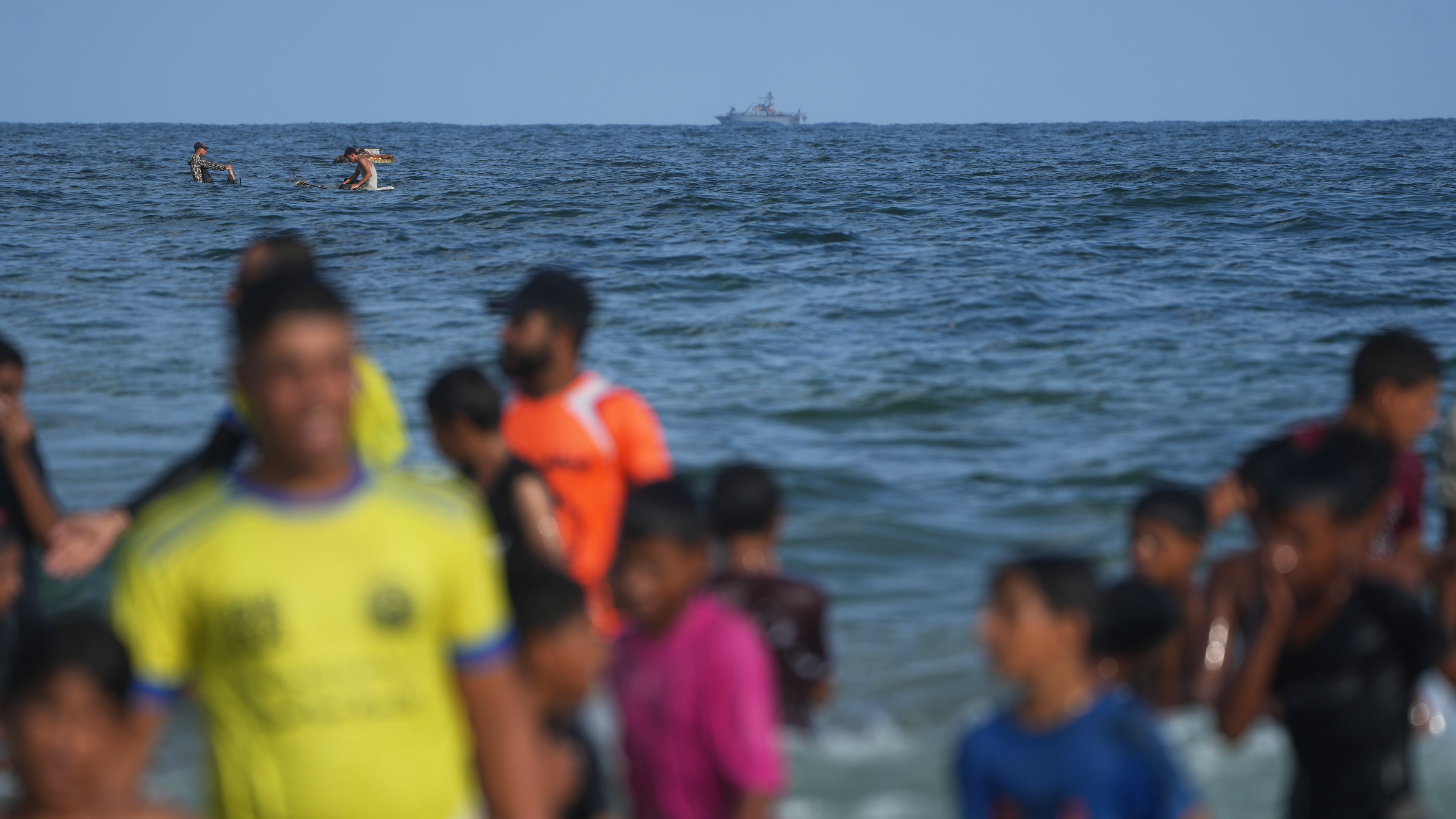 An Israeli navy vessel patrols off the Mediterranean coast as Palestinian children participate in the "Swimming with Gaza" event in Khan Younis, southern Gaza Strip, Friday, Aug. 21, 2026. (AP Photo/Abdel Kareem Hana)