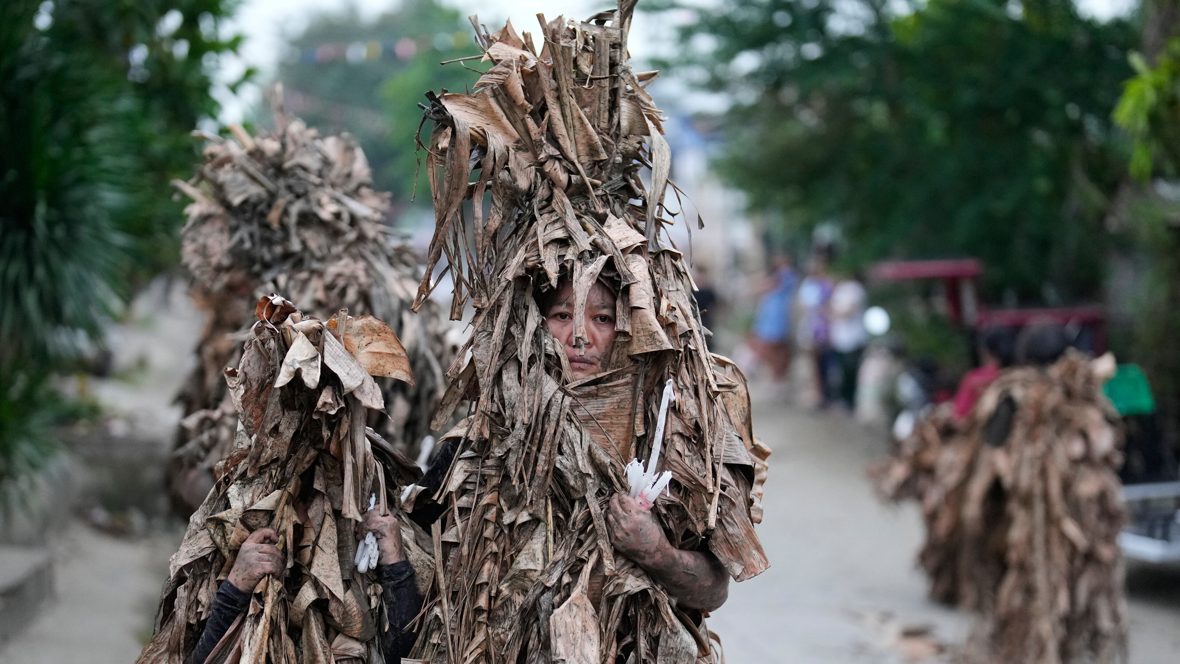 Catholic devotees covered in mud and dried banana leaves join the mud people festival on the feast day of Saint John the Baptist at Bibiclat, Nueva Ecija province, northern Philippines on Wednesday, June 24, 2026. (AP Photo/Aaron Favila)
