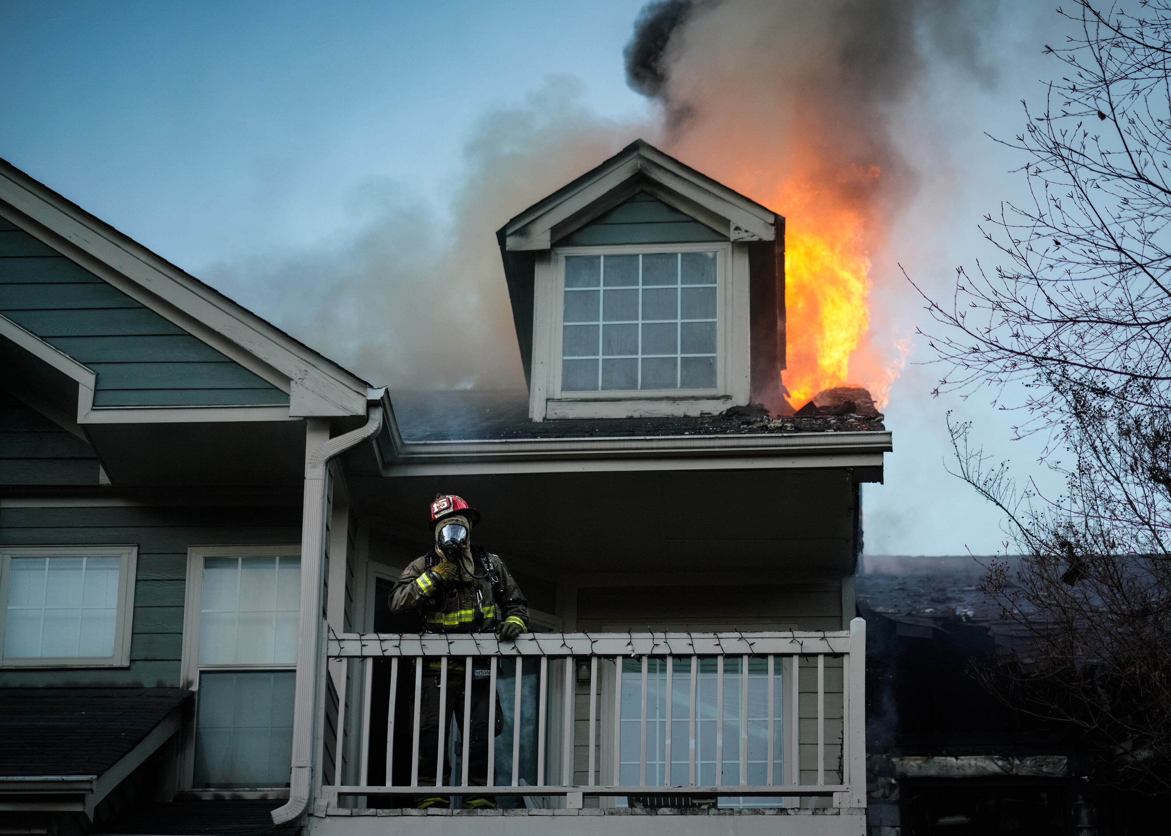 An Atlanta firefighter stands on the third story of a burning apartment building on Cityline Avenue in downtown Atlanta on Monday. (Ben Hendren for the Atlanta Journal-Constitution)