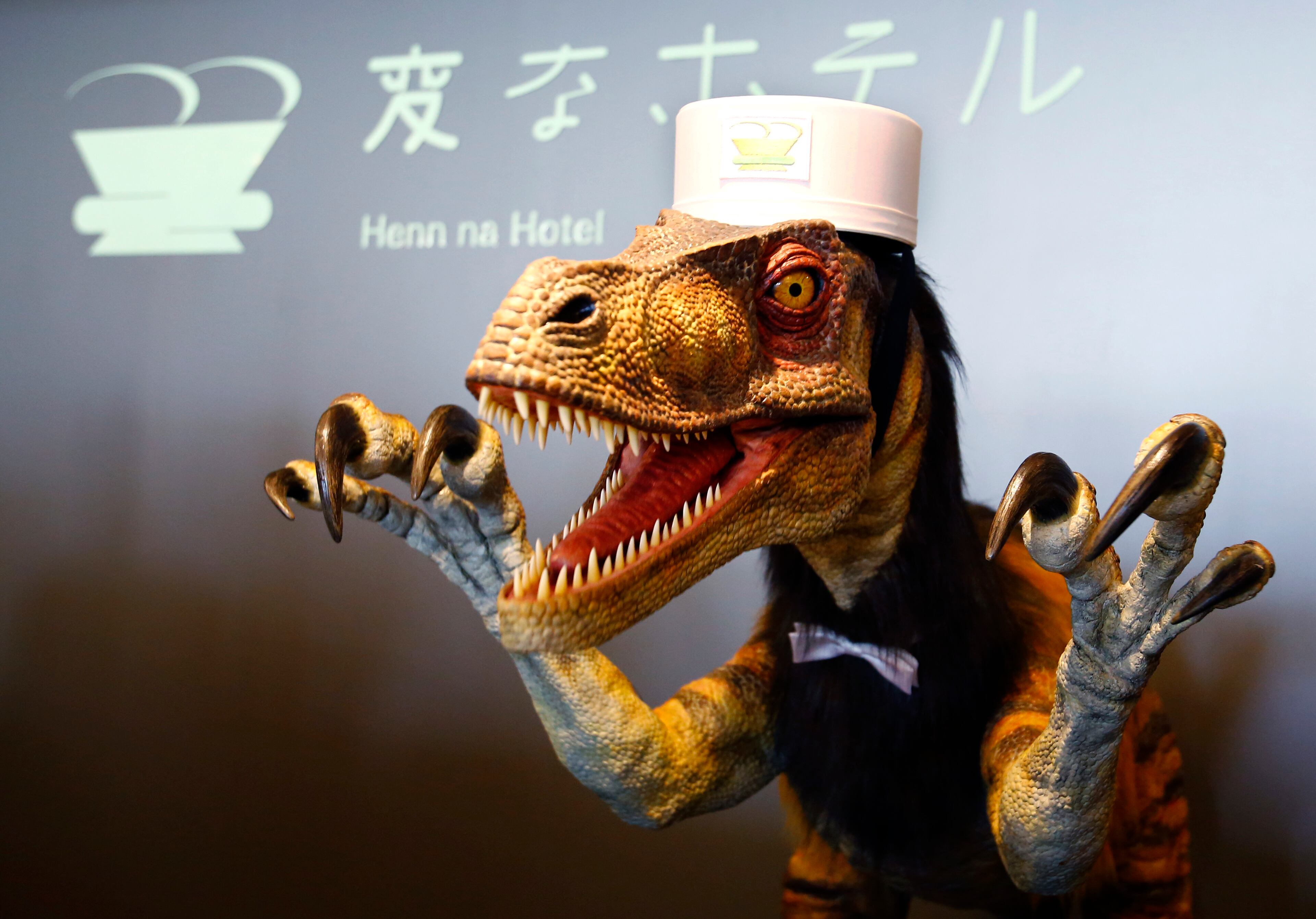 A receptionist dinosaur robot performs at the new robot hotel, aptly called Henn na Hotel or Weird Hotel, in Sasebo, southwestern Japan, Wednesday, July 15, 2015. From the receptionist that does the check-in and check-out to the porter that's a stand-on-wheels taking luggage up to the room, the hotel, that is run as part of Huis Ten Bosch amusement park, is "manned" almost totally by robots to save labor costs. (AP Photo/Shizuo Kambayashi)