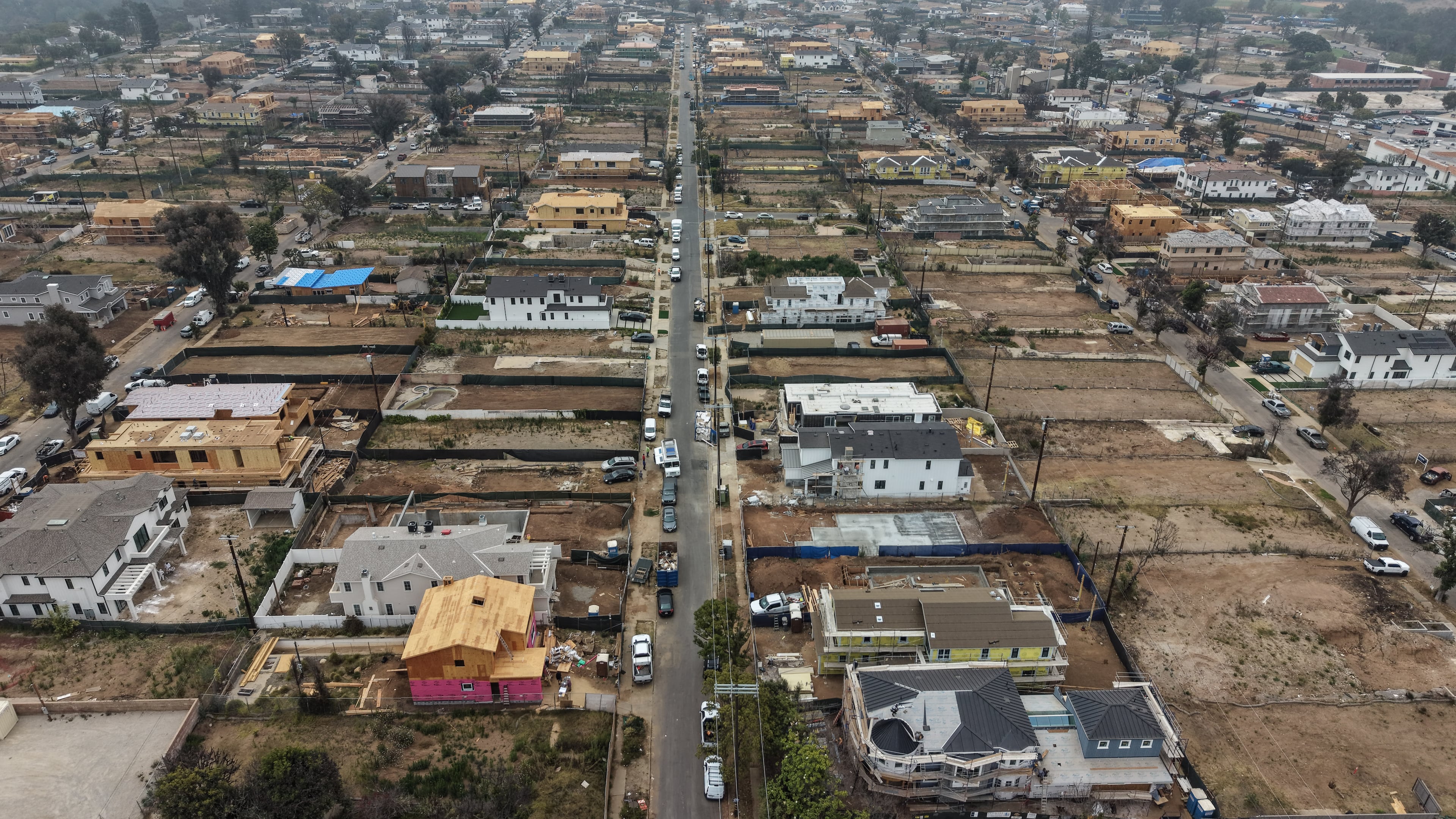 FILE - An aerial view shows homes under construction amid empty lots, June 4, 2026, more than a year after the Palisades Fire in the Pacific Palisades neighborhood of Los Angeles. (AP Photo/Jae C. Hong, File)