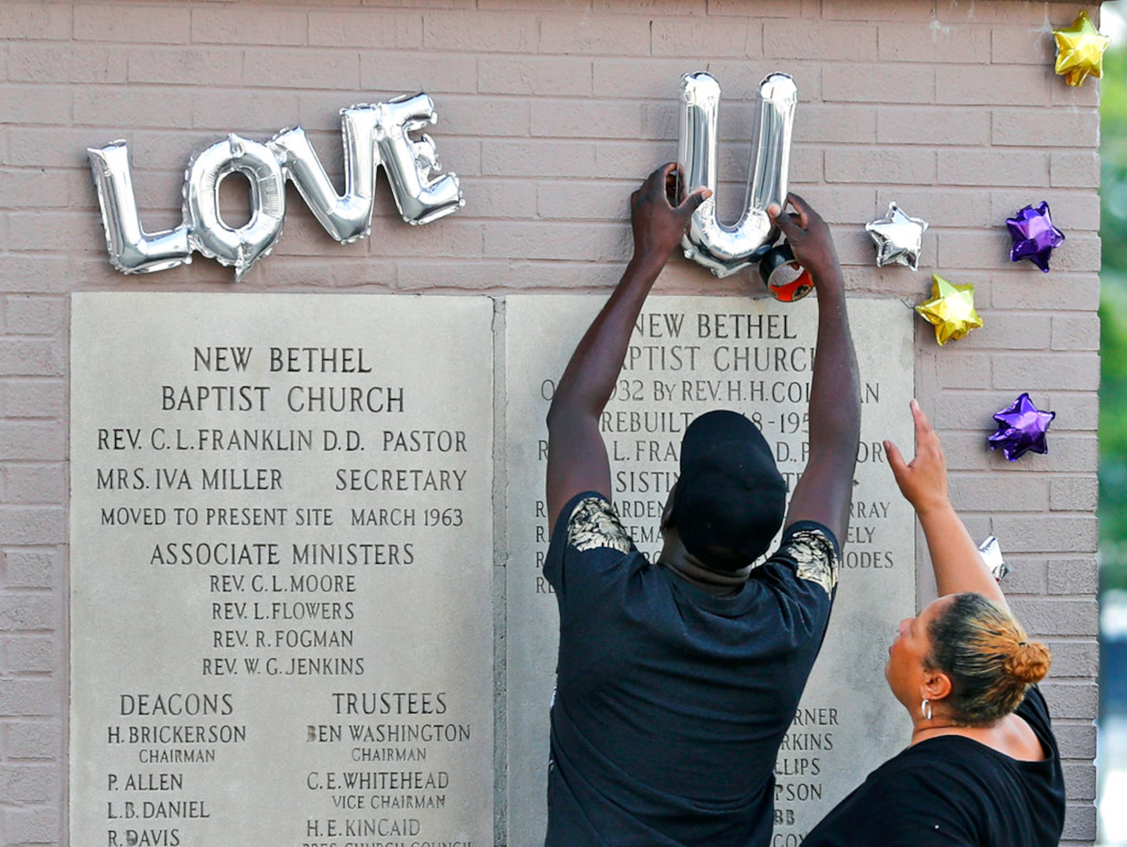 People hang balloons outside New Bethel Baptist Church where a viewing for Aretha Franklin is held Thursday, Aug. 30, 2018, in Detroit. Franklin died Aug. 16, 2018 of pancreatic cancer at the age of 76. (AP Photo/Jeff Roberson)