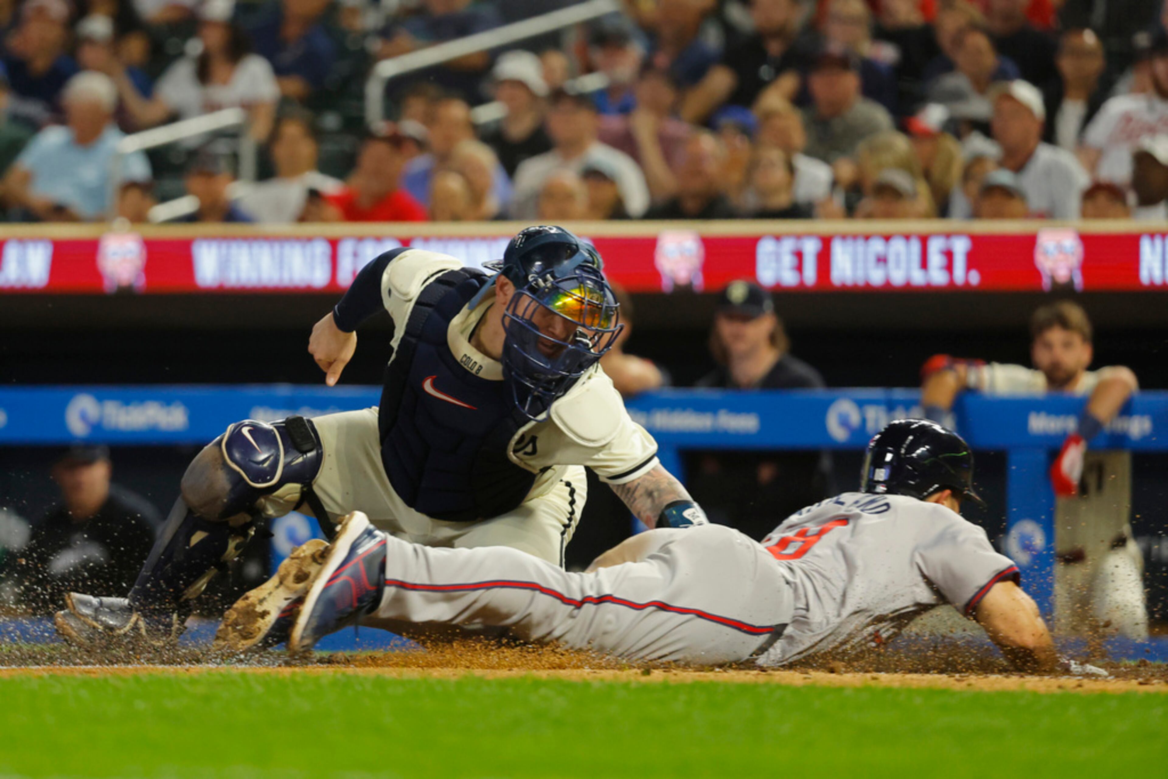 Minnesota Twins catcher Christian Vazquez, left, tags out Atlanta Braves' Ramon Laureano on a fielder's choice in the seventh inning of a baseball game Wednesday, Aug. 28, 2024, in Minneapolis. Initially called safe, a review determined Vazquez applied the tag to Laureano for the out. (AP Photo/Bruce Kluckhohn)