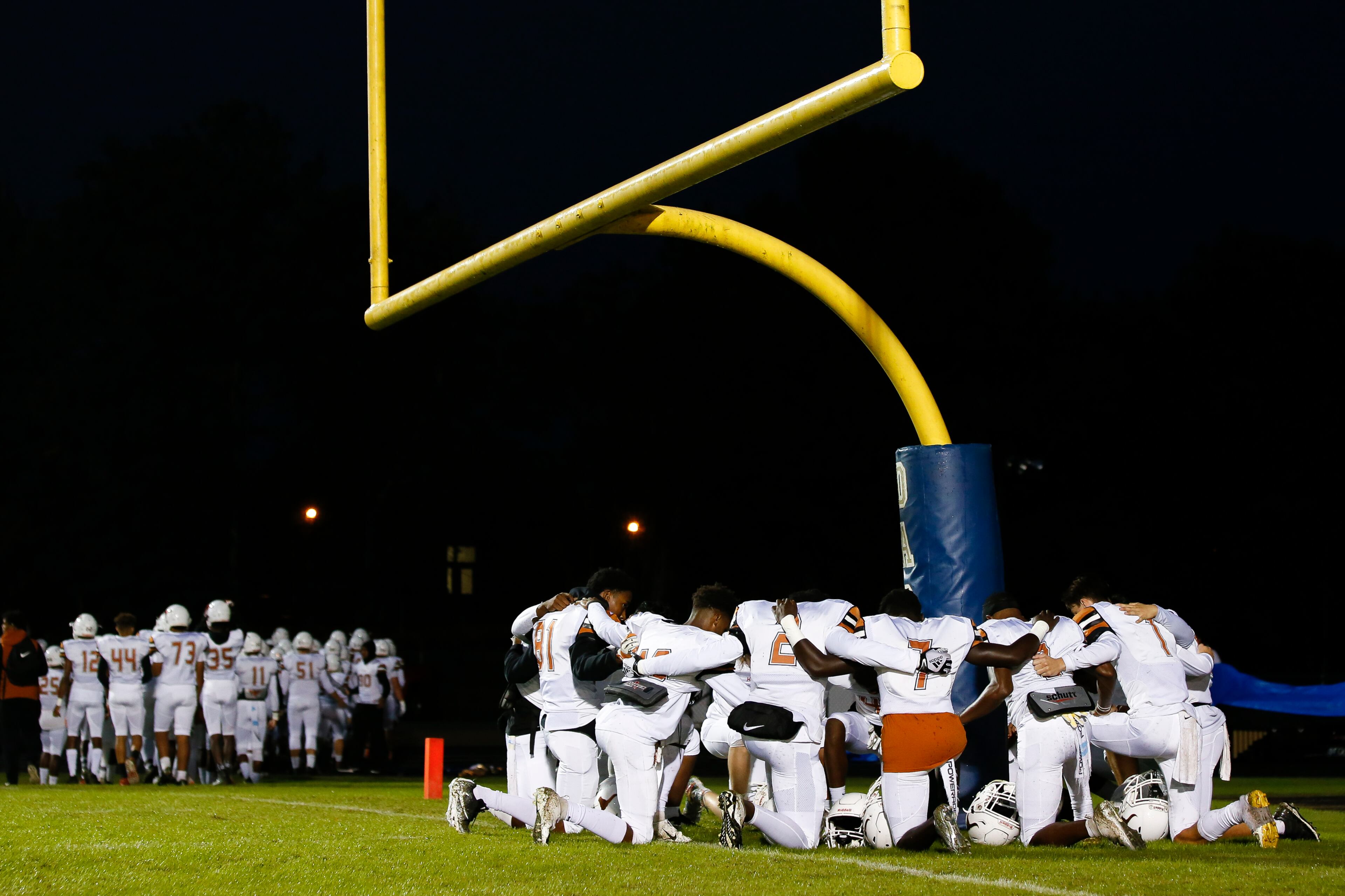 Members of the Lanier varsity football team pray around the goalpost before the start of a high school football game between Lanier and Dacula at Dacula High School in Dacula, Ga., on Friday, Oct. 26, 2018. (Casey Sykes for The Atlanta Journal-Constitution)