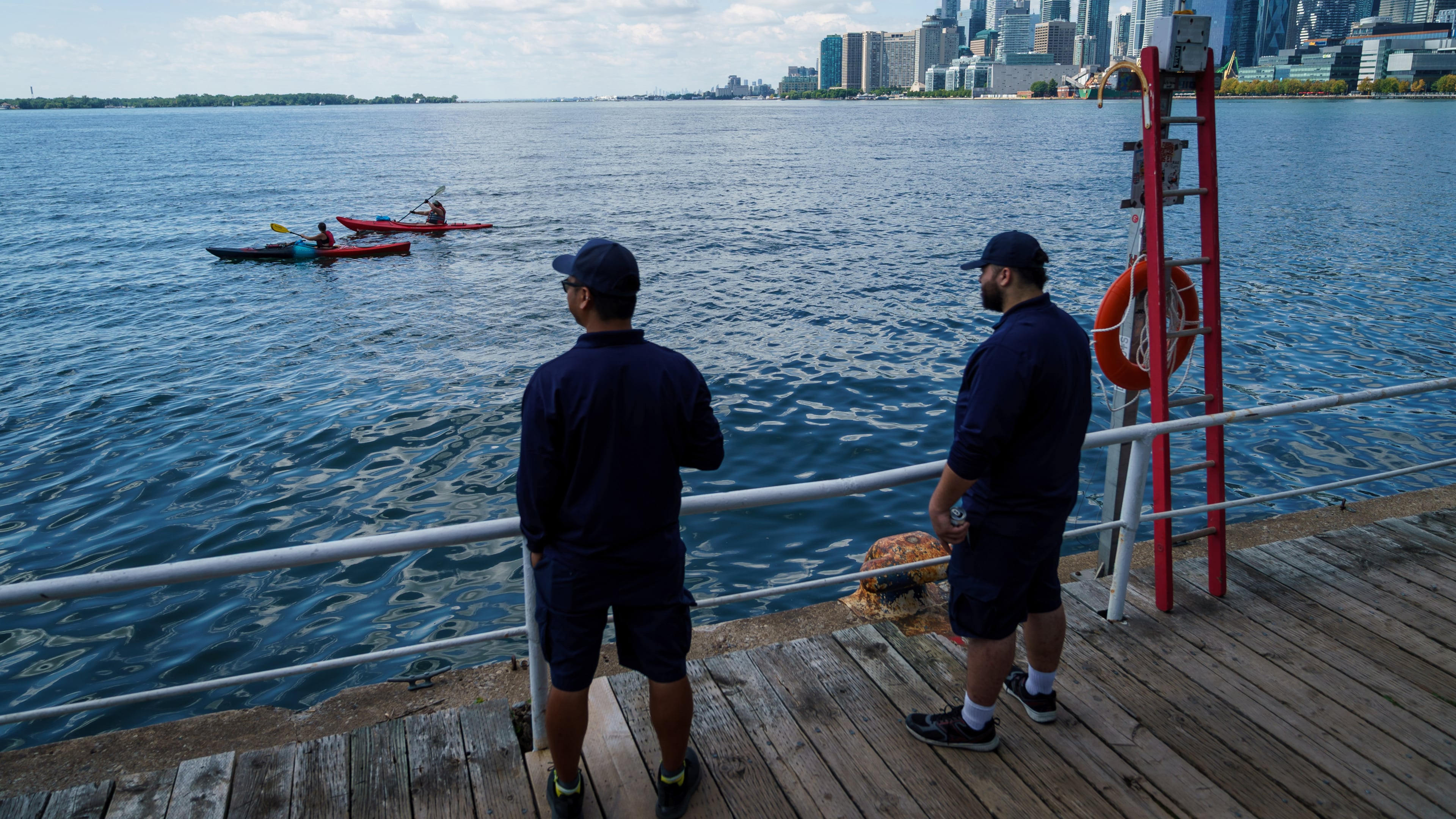 People look out across Lake Ontario from the harbor in Toronto, Tuesday, Aug. 25, 2026. (Keito Newman/The Canadian Press via AP)