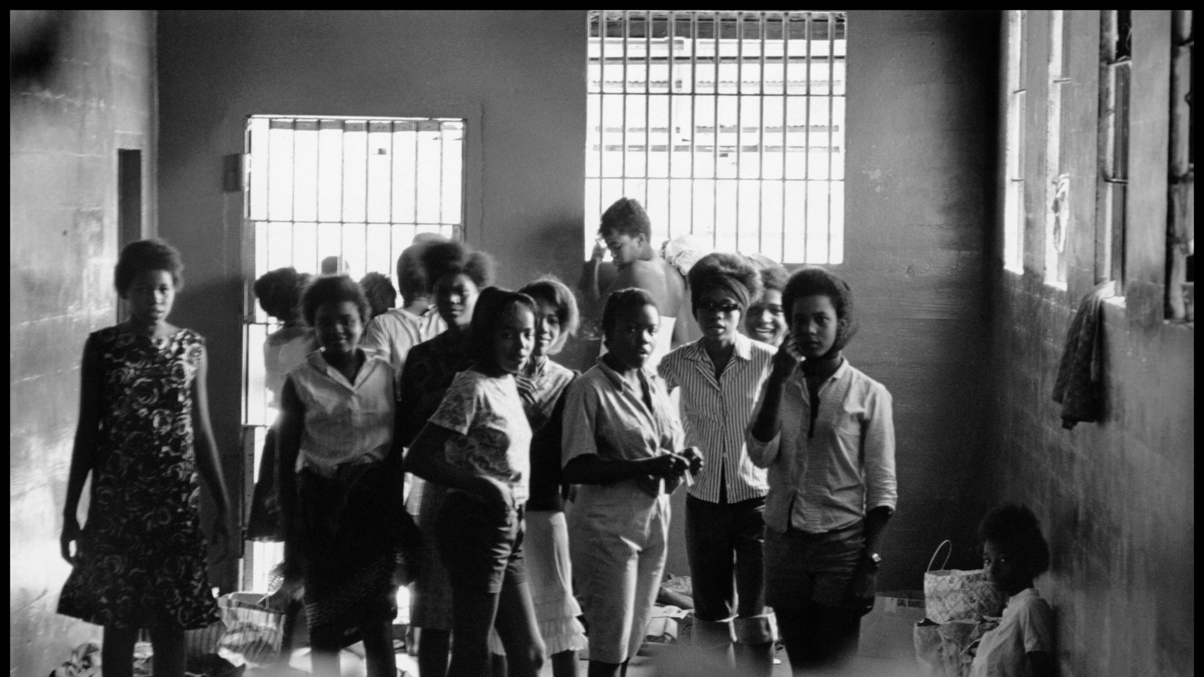 August 1963. Young women are held in the Leesburg Stockade after being arrested for demonstrating in Americus. They have no beds or sanitary facilities. Left to right — Melinda Jones Williams, Laura Ruff Saunders, Mattie Crittenden Reese, Pearl Brown, Carol Barner Seay, Annie Ragin Laster, Willie Smith Davis, Shirley Green and Billie Jo Thornton Allen. Sitting on the floor: Verna Hollis. Photo by and courtesy of DANNY LYON