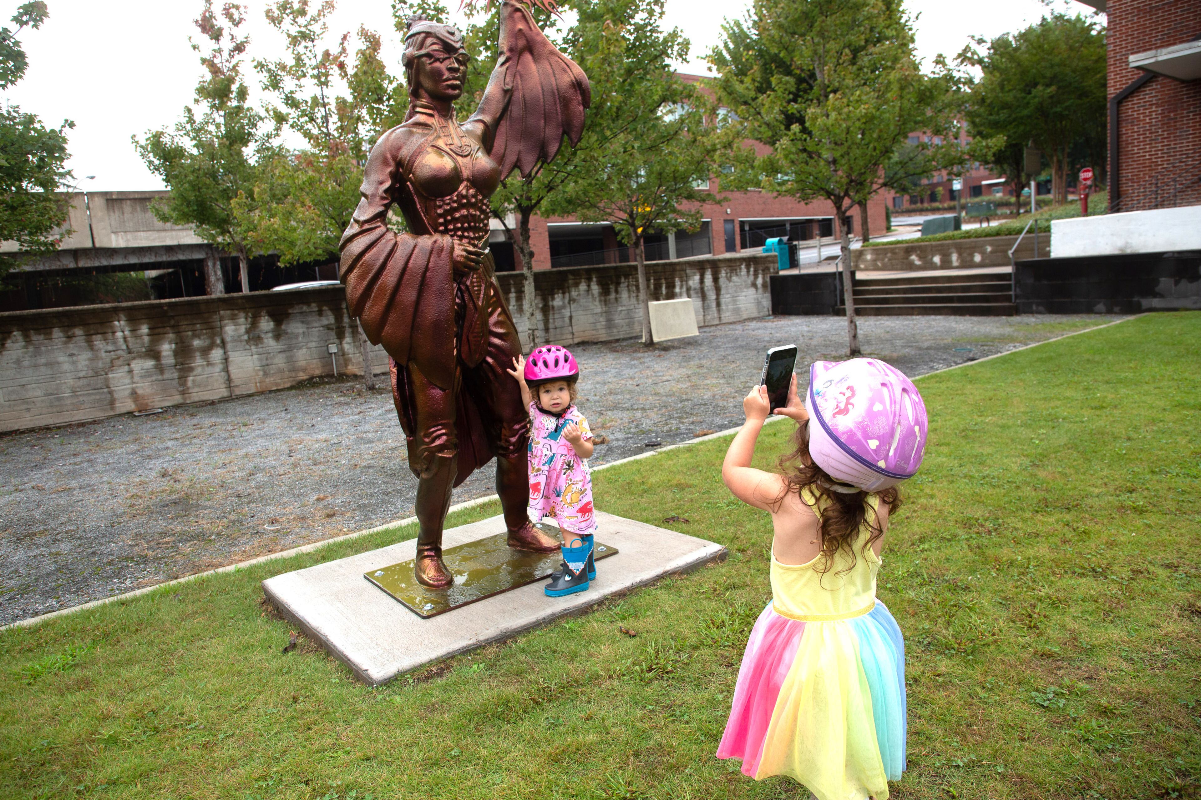 Esme Meraz (right) and her sister Nina admire the new public art sculpture by artist Ellex Swavoni located in the Beacon Municipal Center Plaza in Decatur on Sunday, September 19, 2021. “What Sonia Said” is the name of the phoenix unveiled in a ceremony last week. STEVE SCHAEFER FOR THE ATLANTA JOURNAL-CONSTITUTION