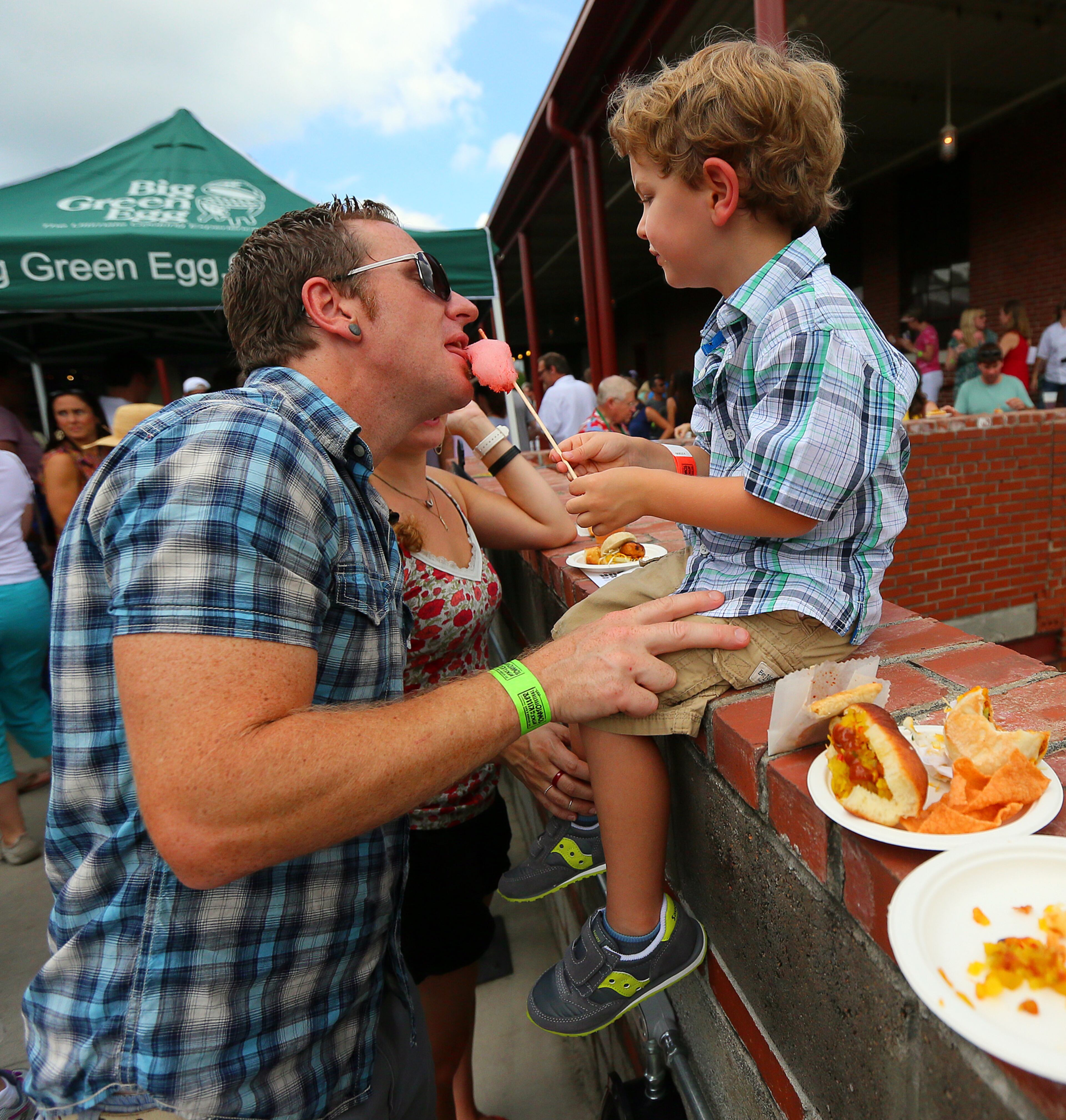 Four-year-old Ethan McIntyre, Atlanta, shares a taste of his tomato-inspired cotton candy with dad, Matt McIntyre, at the JCT.Kitchen & Bar annual Attack of the Killer Tomato Festival
