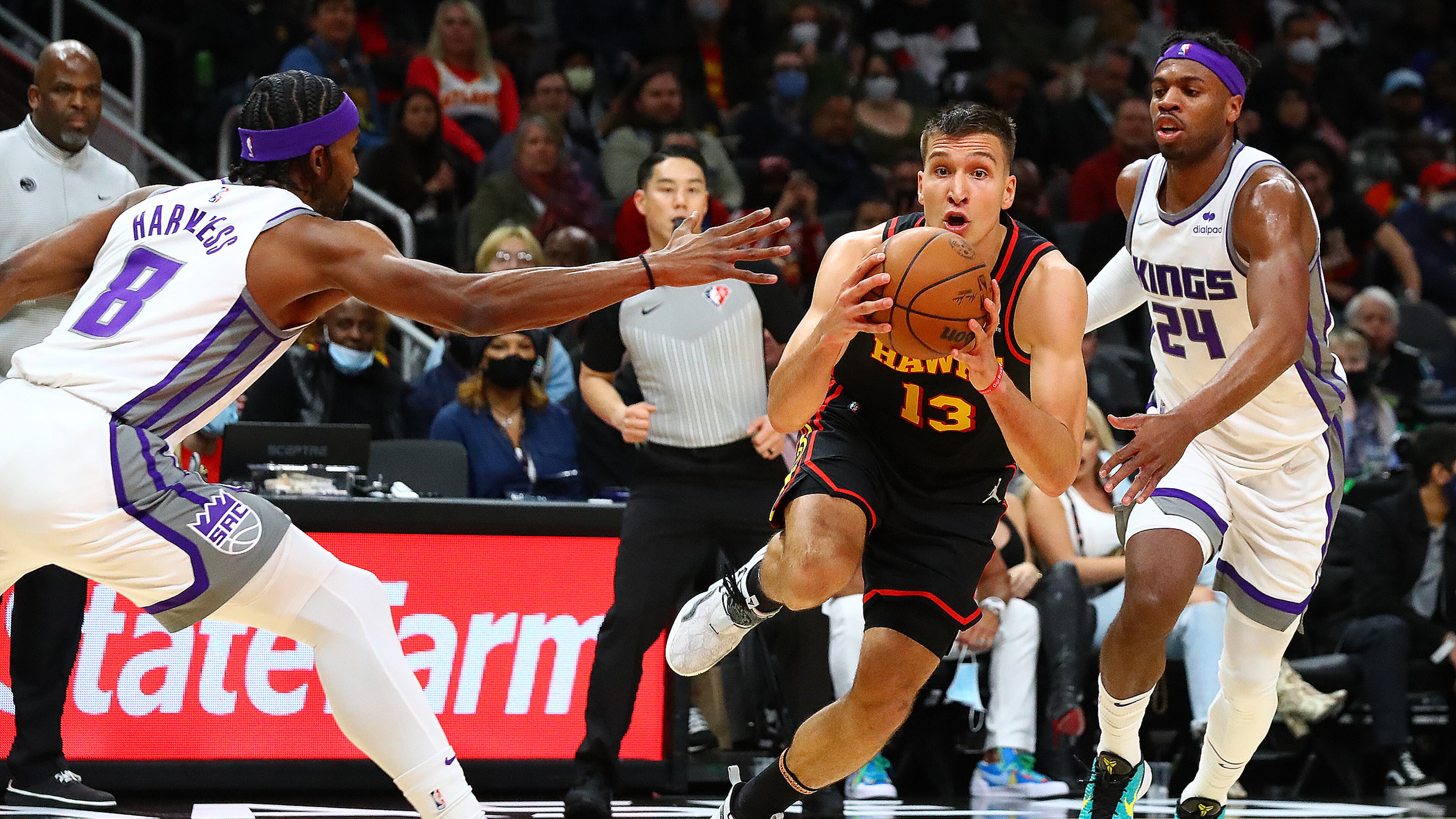 Hawks guard Bogdan Bogdanovic drives with the steal against Sacramento Kings Maurice Harkless (left) and Buddy Hield in a NBA basketball game on Wednesday, Jan. 26, 2022, in Atlanta. “Curtis Compton / Curtis.Compton@ajc.com”`