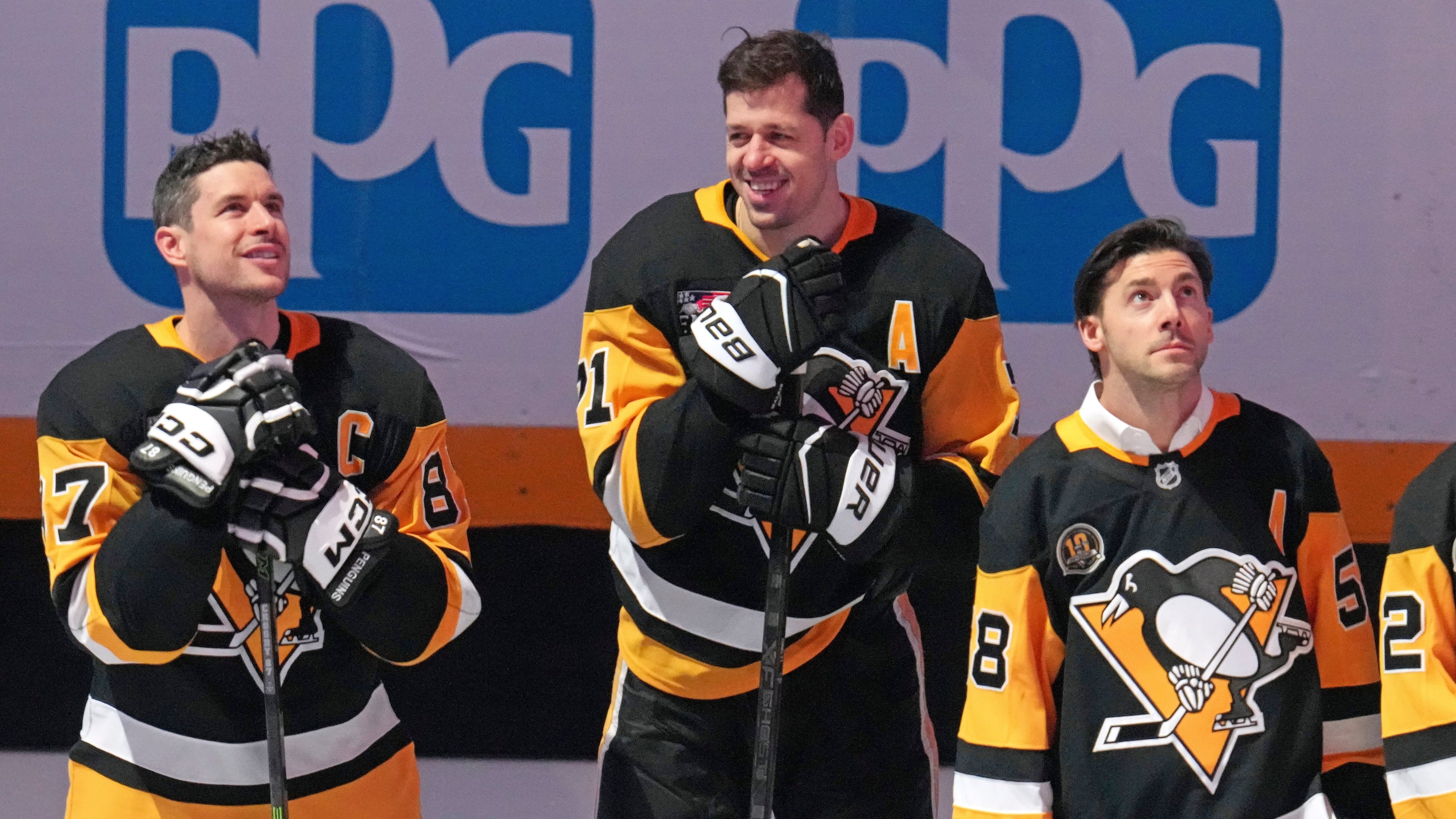 Members of the 2016 Stanley Cup Champion Pittsburgh Penguins, Sidney Crosby, left, Evgeni Malkin, center, and Kris Letang take part in a celebration of the 10th anniversary before an NHL hockey game against the New York Rangers in Pittsburgh, Saturday, Jan. 31, 2026. (AP Photo/Gene J. Puskar)
