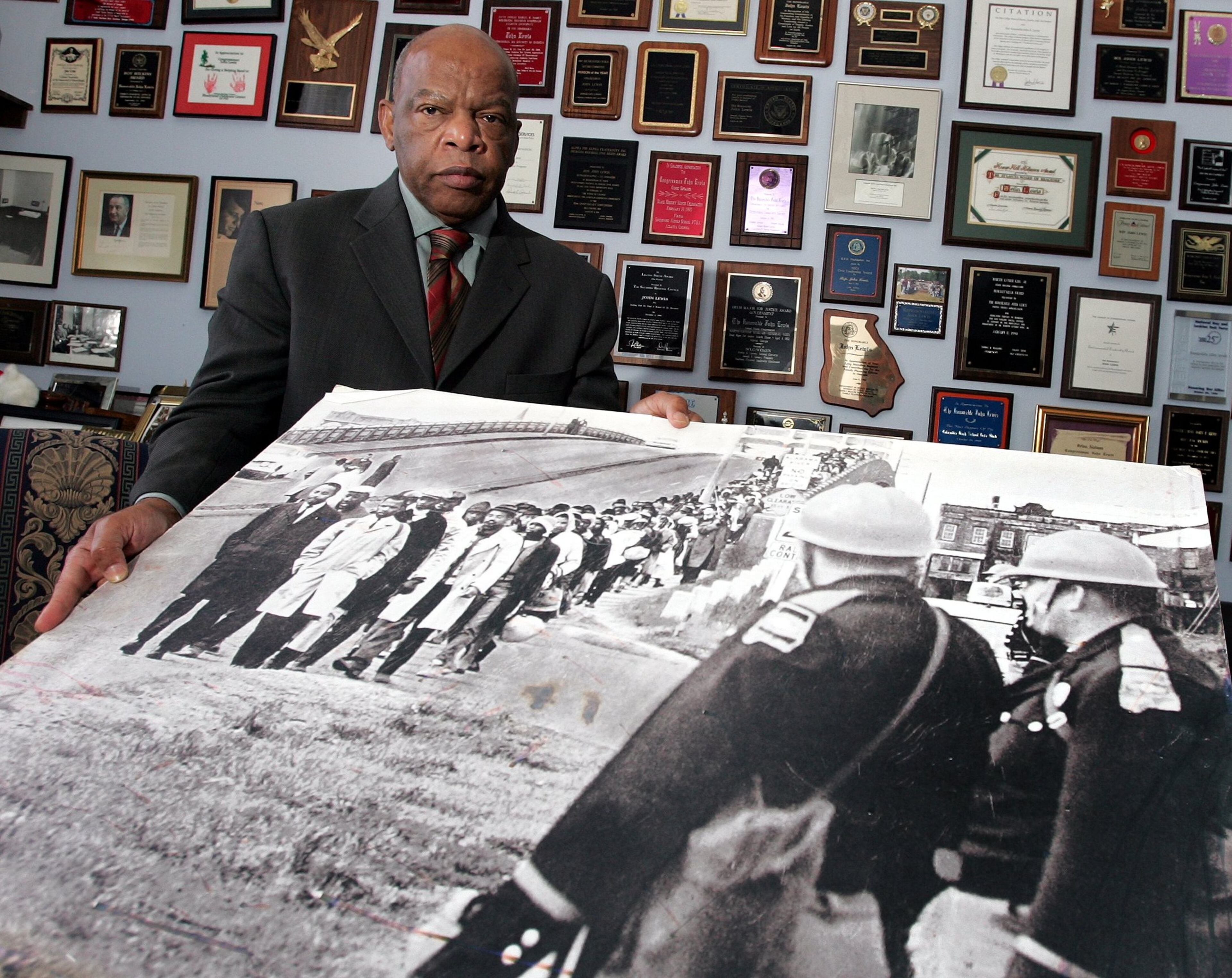 Rep. John Lewis, D-Ga., holds an enlargement of a photo of the Sunday March 7, 1965 march across the Edmund Pettis Bridge in Selma, Alabama. Lewis is at the head of the line in the light coat in the photo.