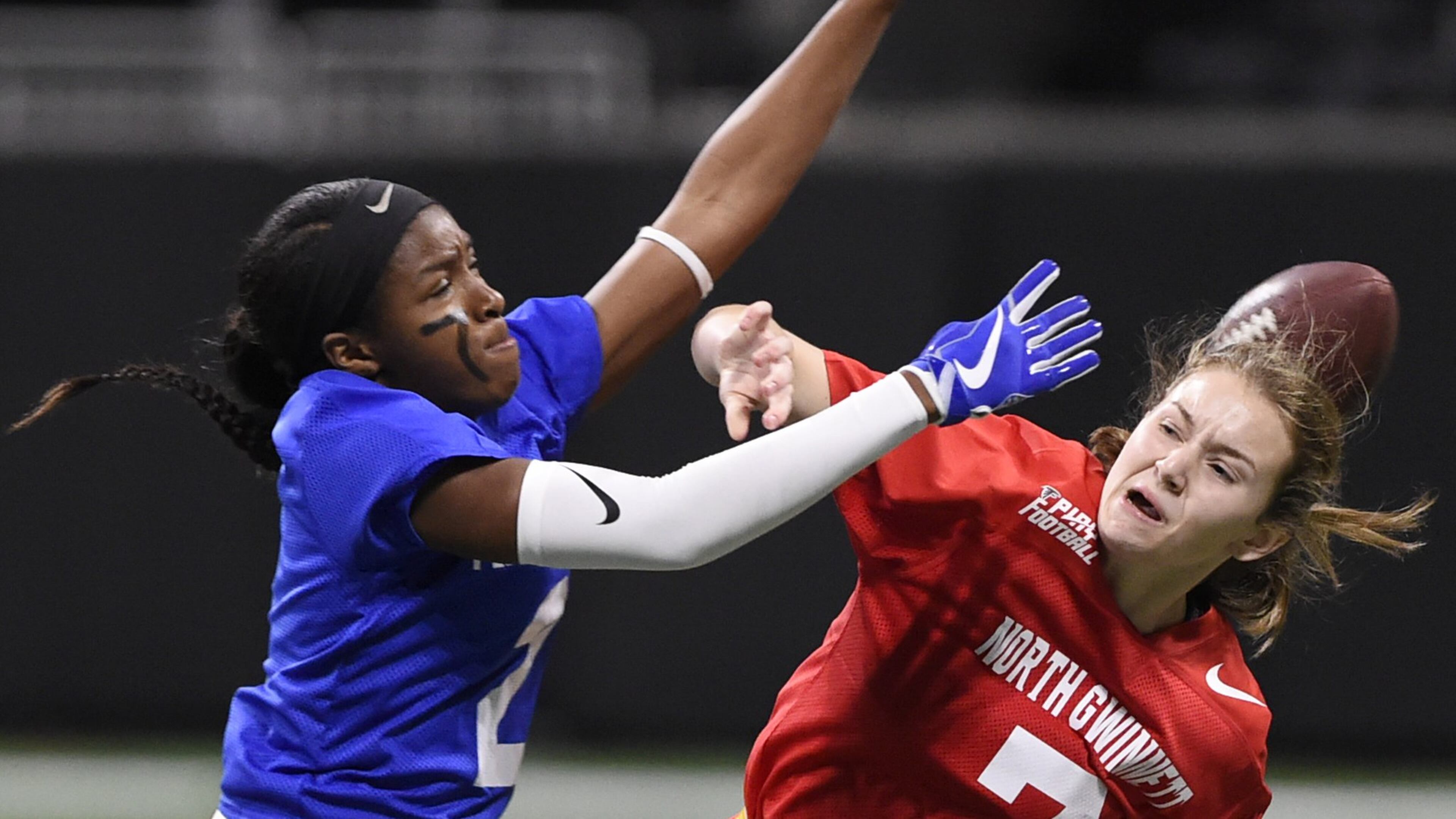 Peachtree Ridge’s Trinity Marshall, left, blocks North Gwinnett’s Sarah Kaufman’s pass during the finals of the flag football championships, Thursday, Dec. 20, 2018 at Mercedes Benz Stadium. North Gwinnett lost the game. (Annie Rice/AJC)