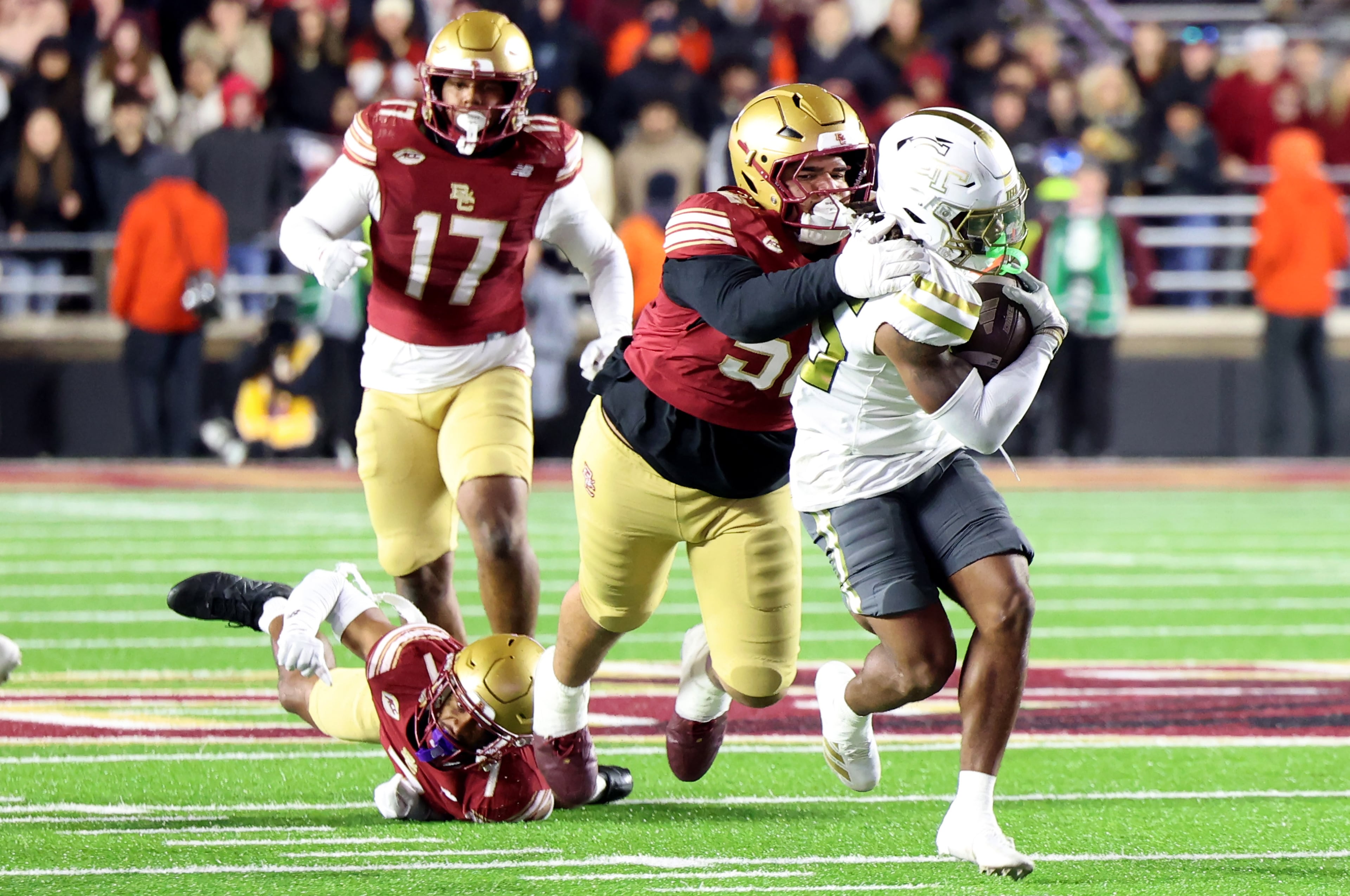 Boston College defensive lineman Chris Marable Jr., right, is tackled Georgia Tech wide receiver Jordan Allen, second from right, during the second half of an NCAA college football game Saturday, Nov. 15, 2025, in Boston. (AP Photo/Mark Stockwell)
