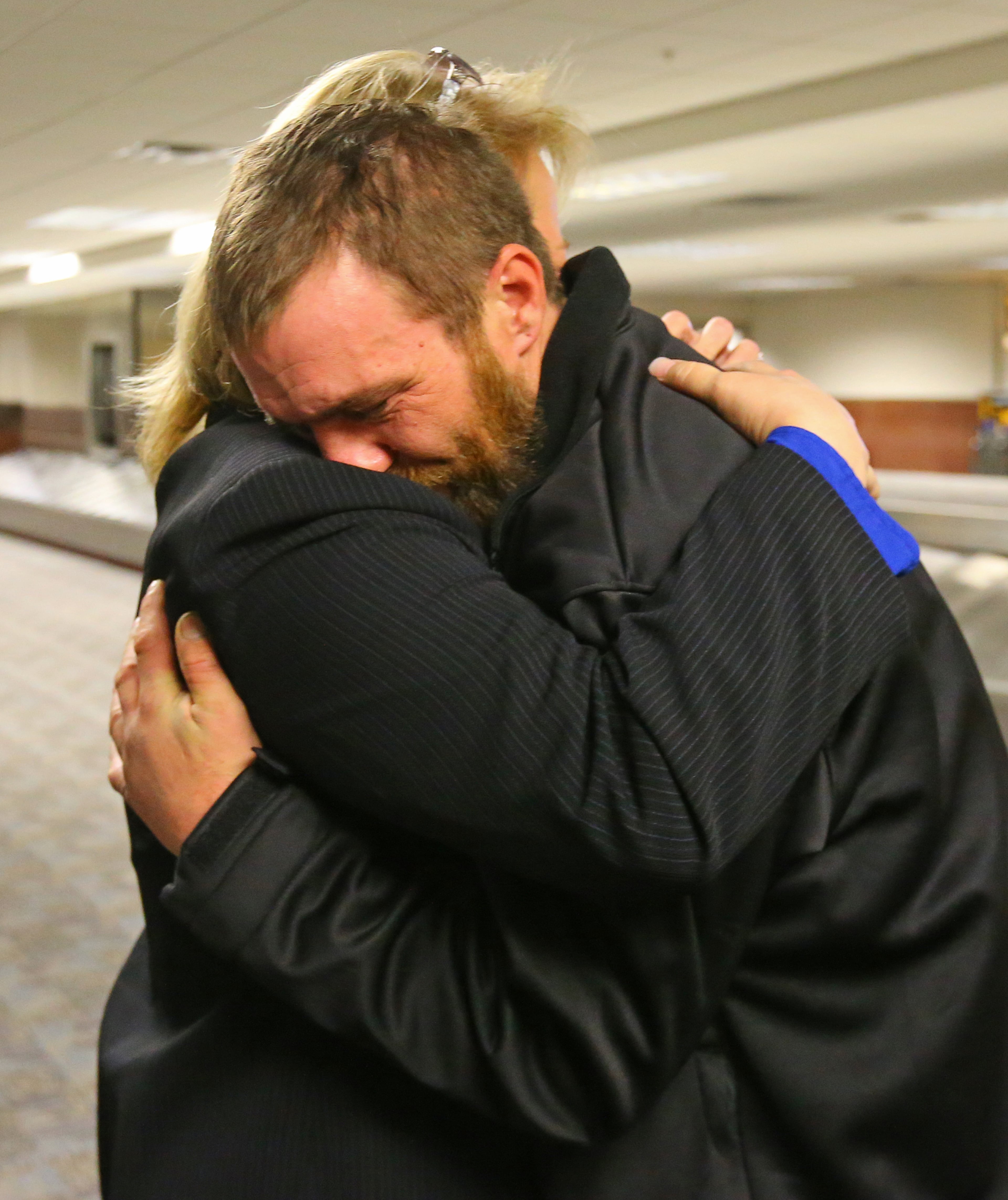 112813 ATLANTA: Joel Hartman embraces his stepmother Deanna Rodecki, who has been searching for him for more than a decade, at Hartsfield Jackson Airport for for Thanksgiving on Thursday, Nov. 28, 2013, in Atlanta. CURTIS COMPTON /staff CCOMPTON@AJC.COM