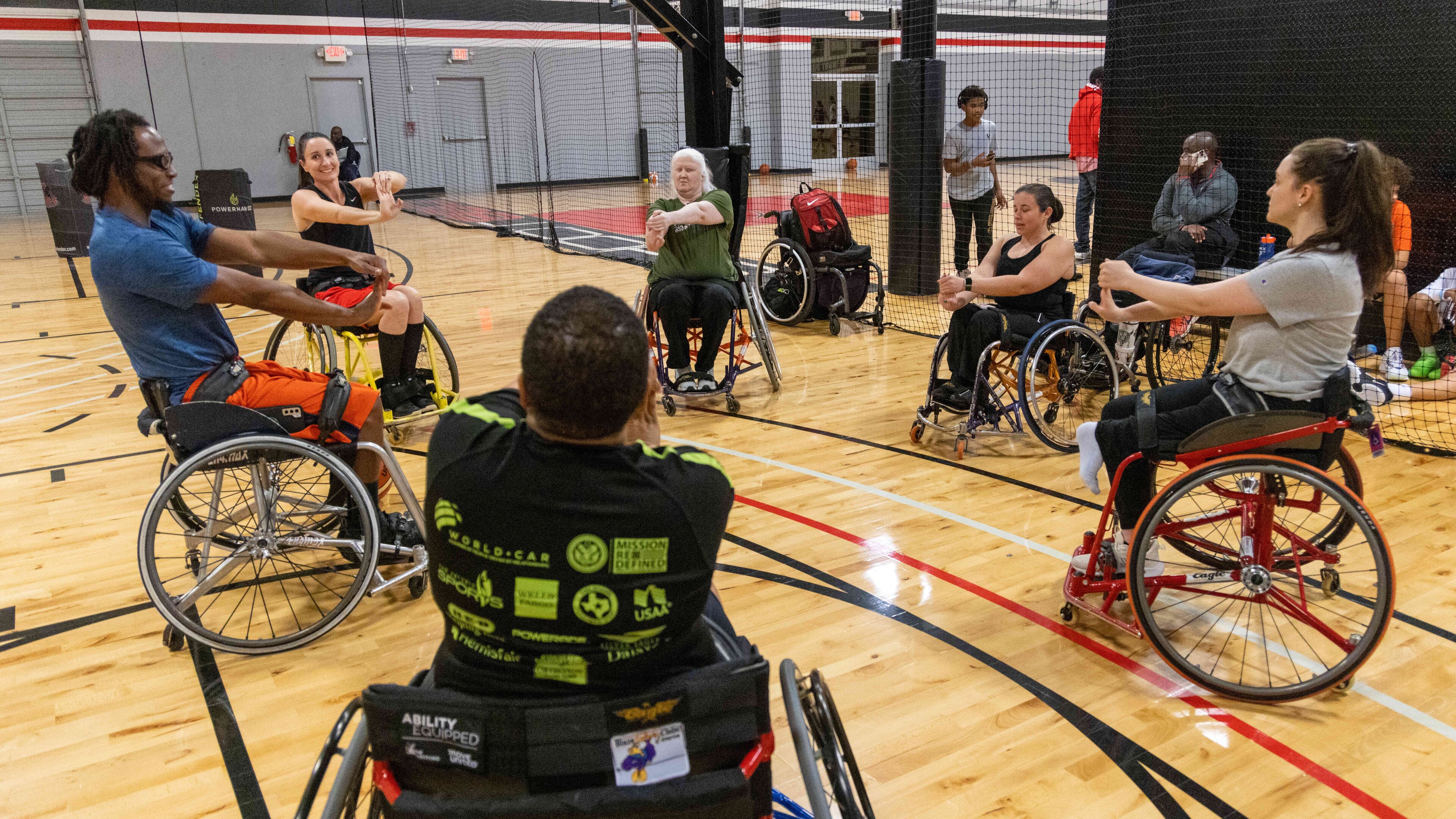 Martinez Johnson (left) leads the The Lady Ballers wheelchair team members in stretches before practice at Shoot 360 in Alpharetta on Jan. 11, 2023. Blazesports America is helping The Atlanta Hawks launch Georgia's first women's wheelchair basketball team. PHIL SKINNER FOR THE ATLANTA JOURNAL-CONSTITUTION