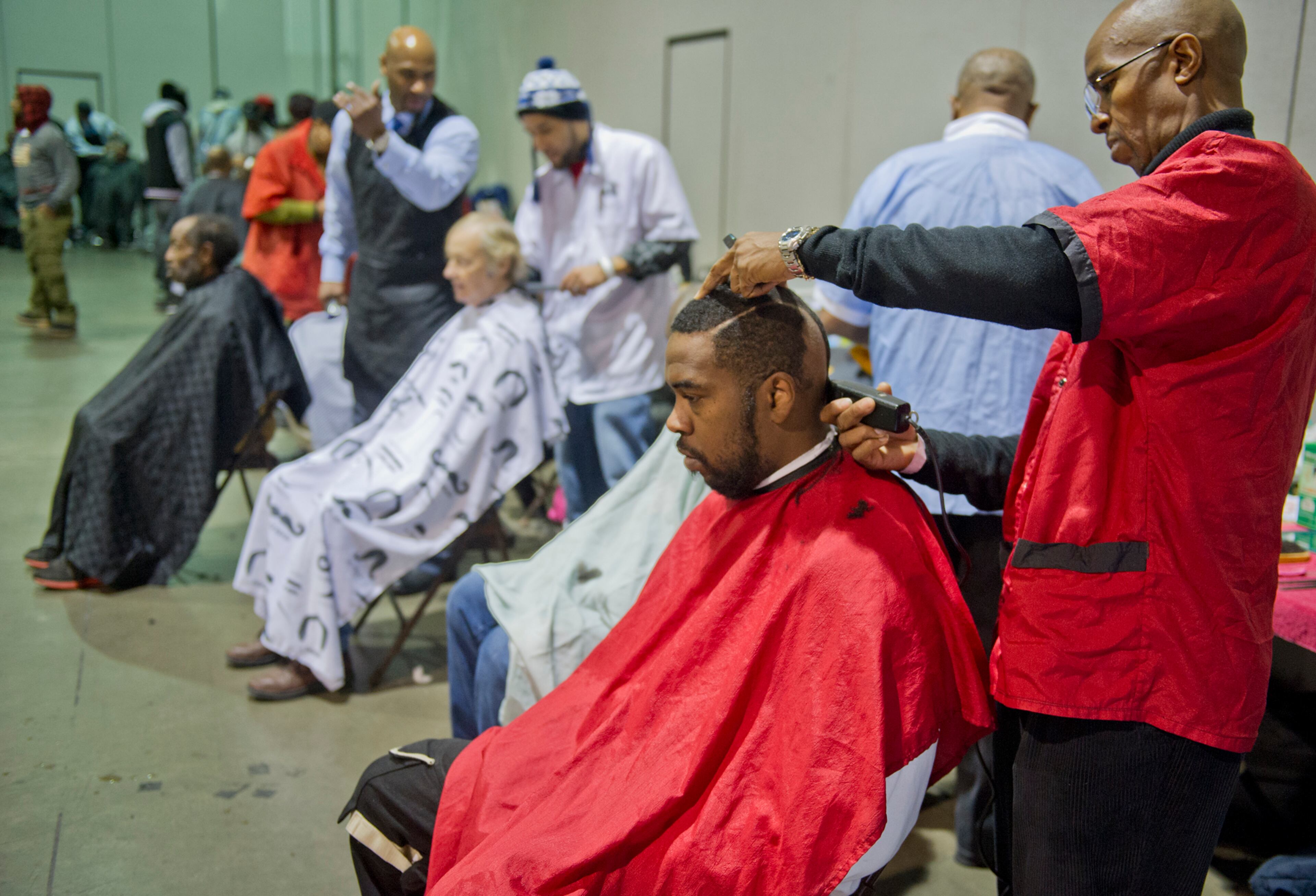 Charles Bracks (right) gives a haircut to Mike Banks during the Hosea Feed the Hungry and Homeless annual Thanksgiving meal at the Georgia World Congress Center in Atlanta on Nov. 28, 2013.