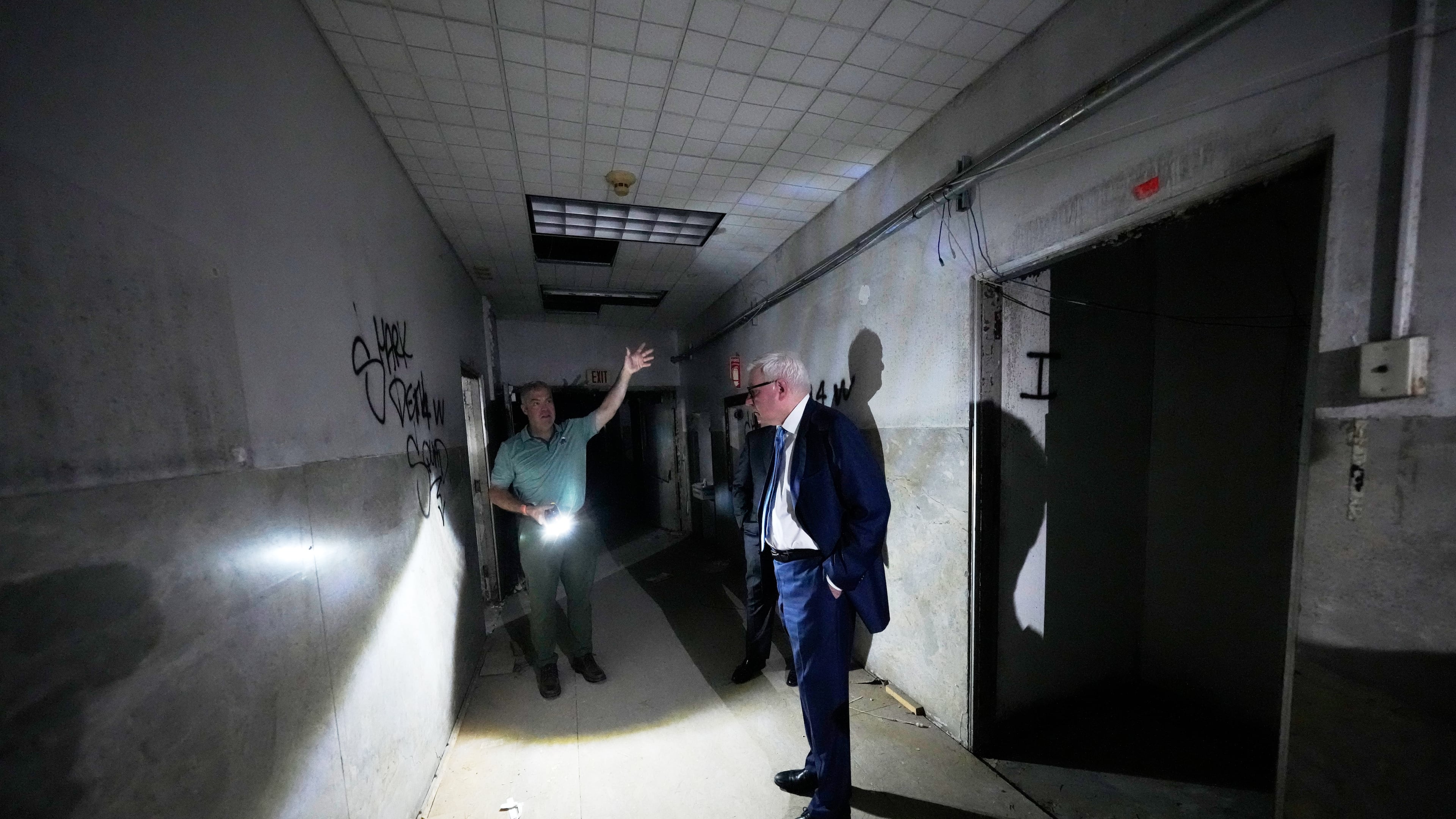 Patrick Norton, Tulane University senior vice president, chief operating officer and treasurer, right, and Jeff Benjamin, vice president of facilities and campus development, talk in a hallway inside the old Charity Hospital building Wednesday, Aug. 19, 2026, in New Orleans. (AP Photo/Gerald Herbert)