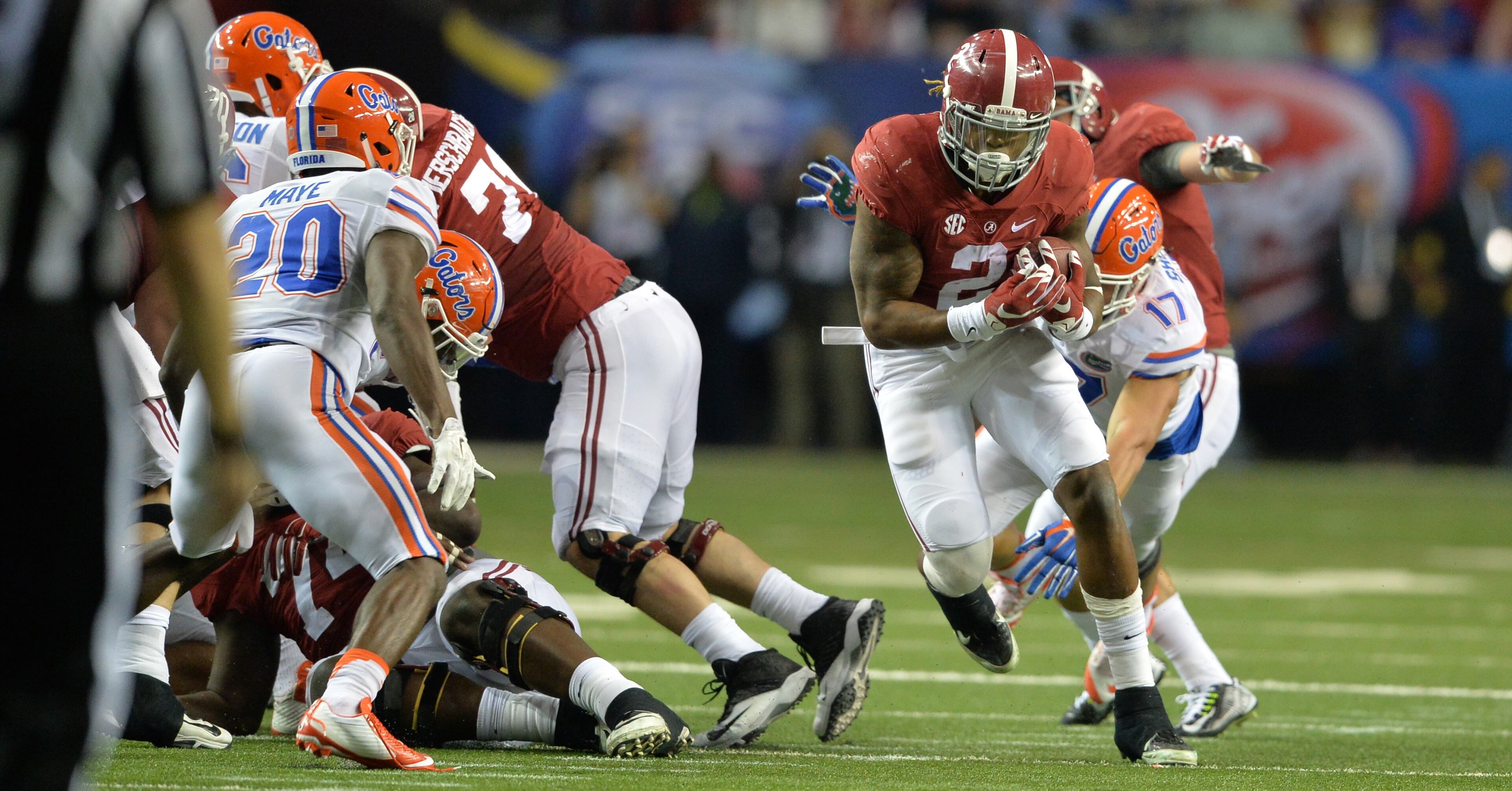 December 5, 2015 Atlanta: Alabama Crimson Tide running back Derrick Henry avoids the tackle of Florida Gators defensive lineman Jordan Sherit during the first half of the SEC Championship at the Georgia Dome Saturday December 5, 2015. BRANT SANDERLIN/BSANDERLIN@AJC.COM