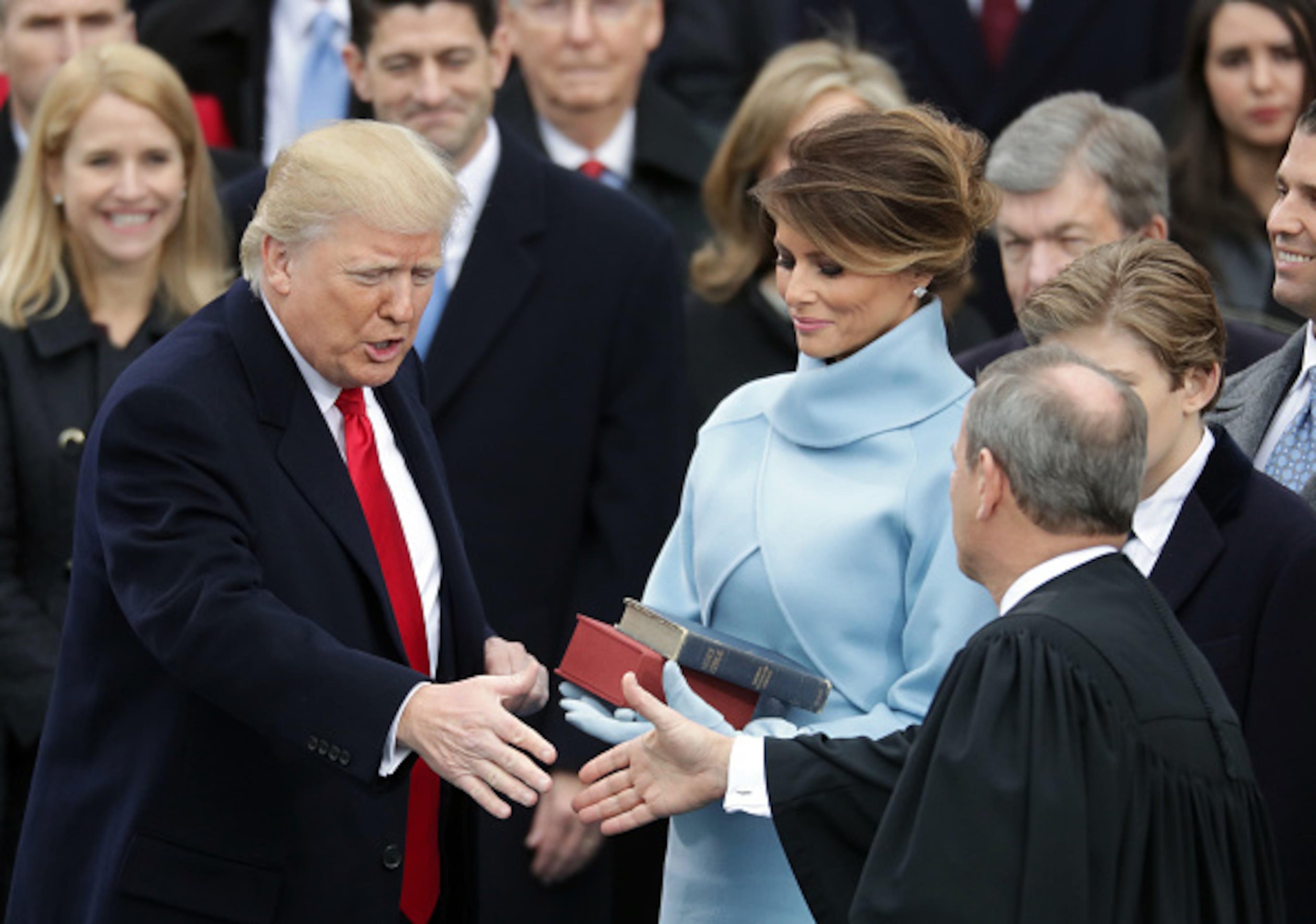 WASHINGTON, DC - JANUARY 20: Supreme Court Justice John Roberts (R) congratulates U.S. President Donald Trump (L) after administering the oath of office as his wife Melania Trump holds the Bible, on the West Front of the U.S. Capitol on January 20, 2017 in Washington, DC. In today's inauguration ceremony Donald J. Trump becomes the 45th president of the United States. (Photo by Chip Somodevilla/Getty Images)