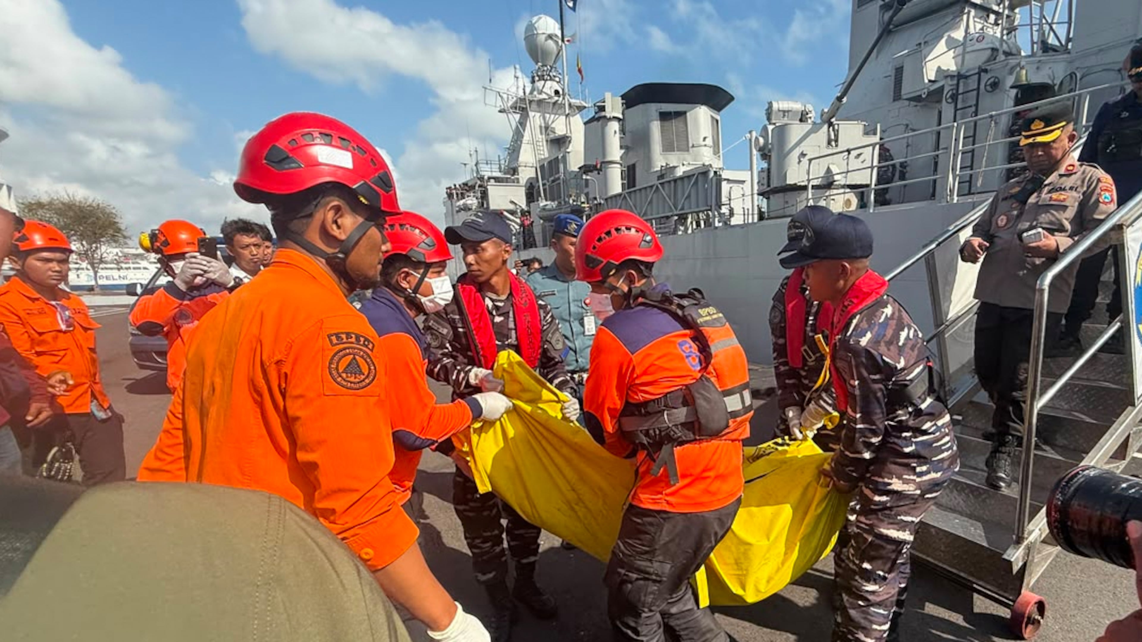 In this photo released by the Indonesian National Search and Rescue Agency (BASARNAS), rescuers carry the body of a victim of a ferry fire upon arrival at Indonesian Navy's 2nd Fleet's pier in Surabaya, East Java, Indonesia, Monday, Aug. 3, 2026. (BASARNAS via AP)