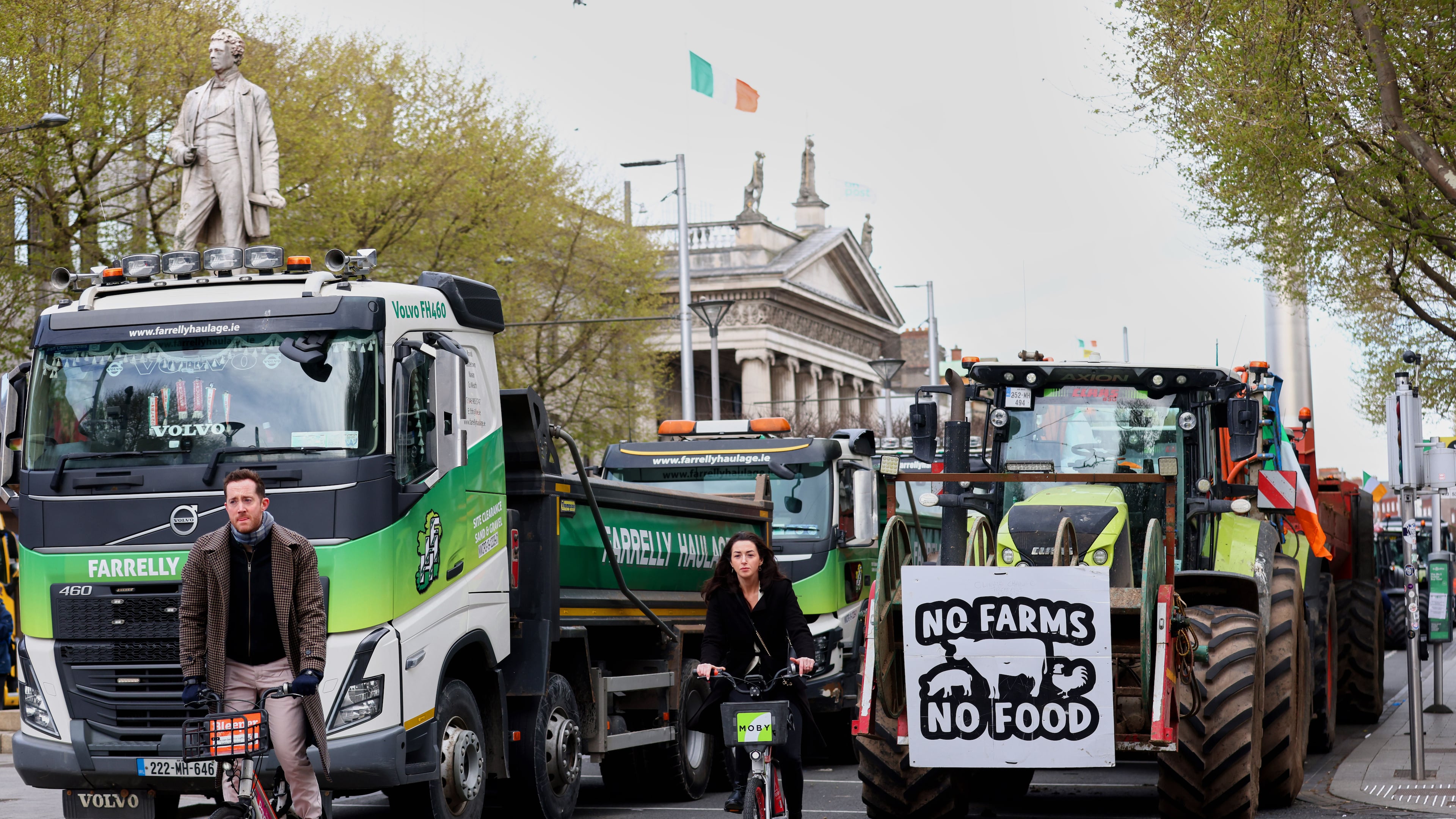 Cyclists ride past tractors blocking O'Connell Street on the fifth day of the National Fuel Protest, in Dublin, Ireland, Saturday, April 11, 2026. (AP Photo/Peter Morrison)