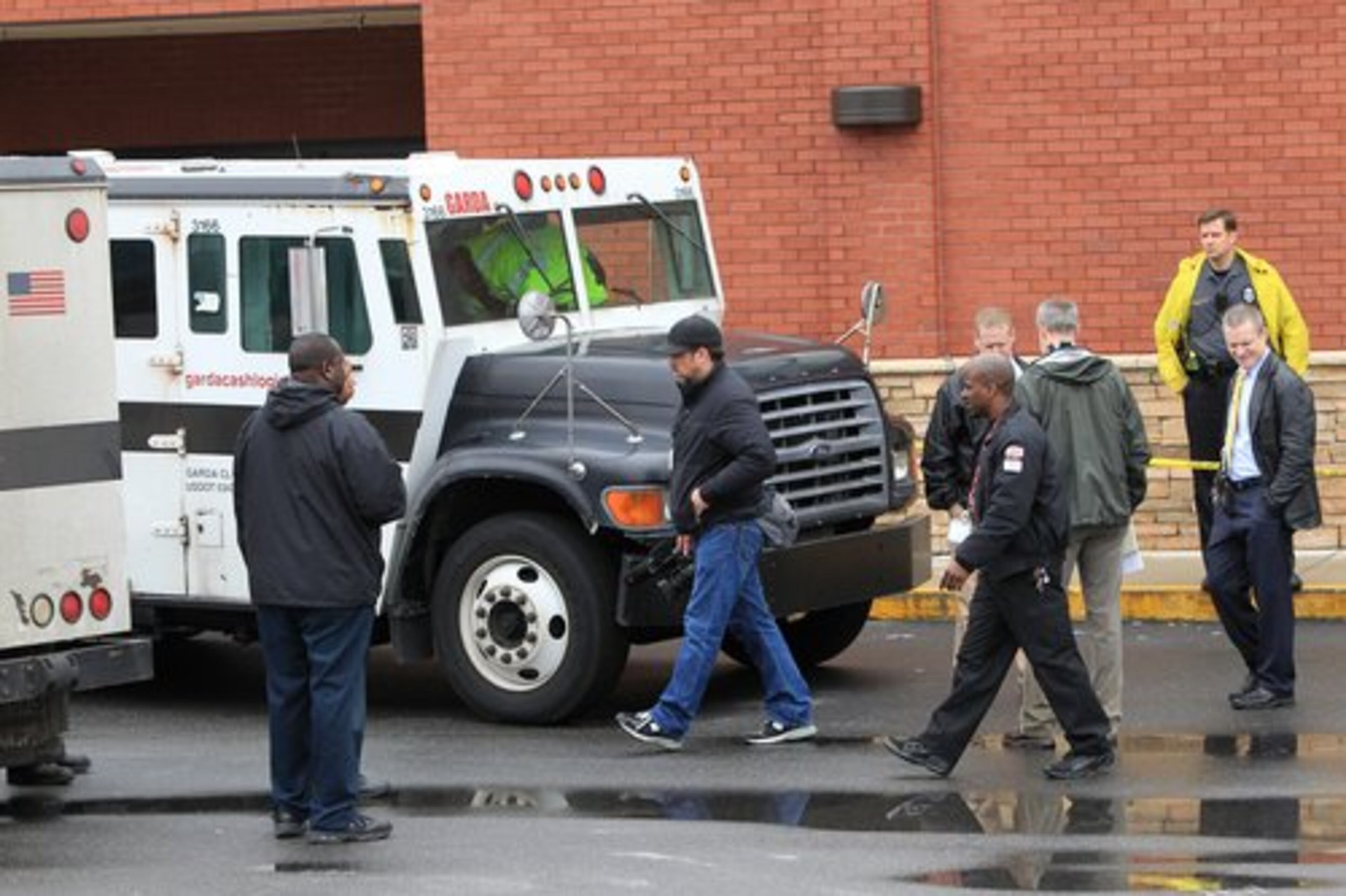 Police and investigators work the scene where two men killed a guard in a daring armored car robbery at the Kroger on Lavista Road at North Druid Hills in Atlanta. Police said the gunman "fired numerous times in an unprovoked fashion" on the courier.