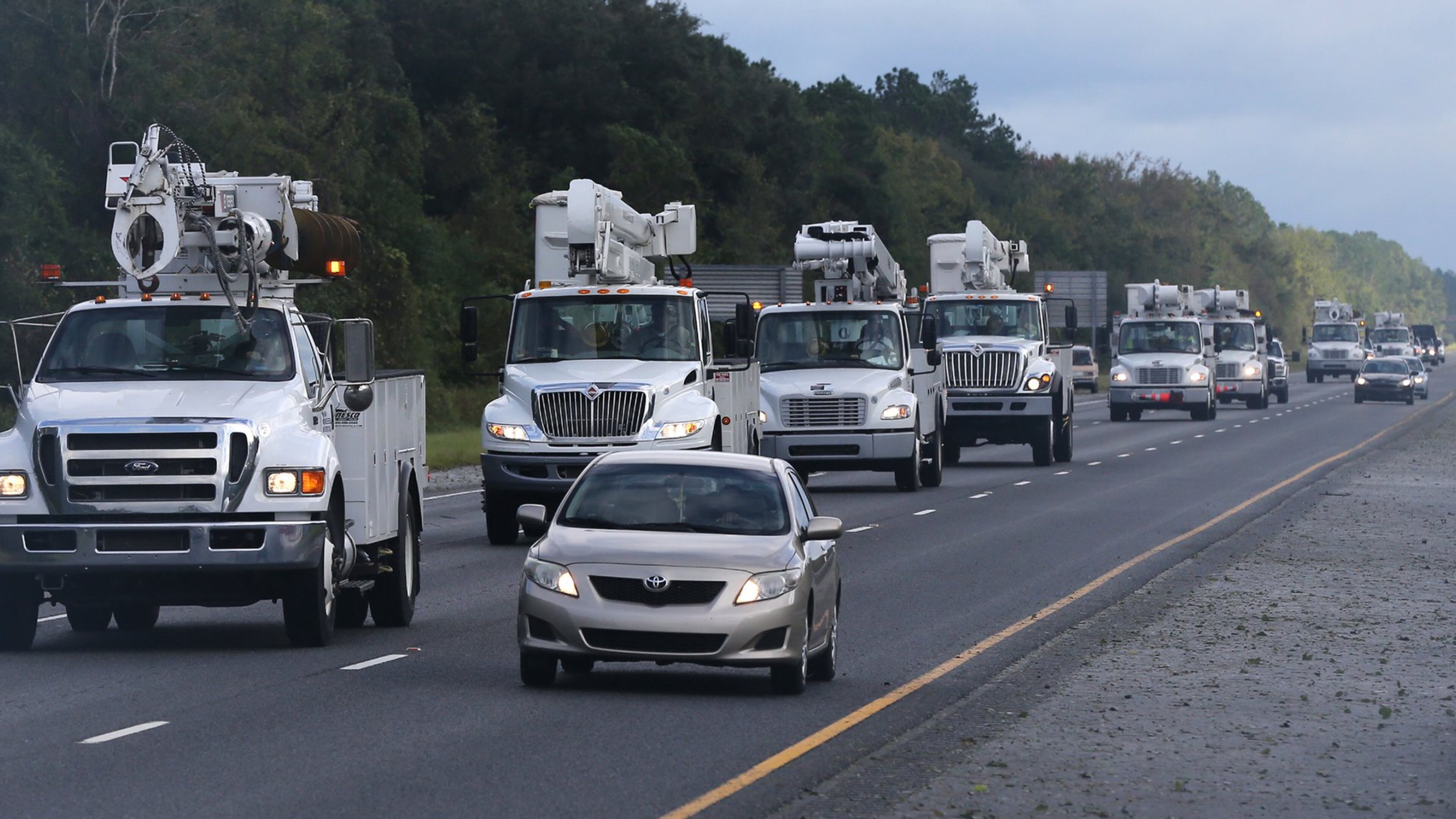 A fleet of power trucks heads south on I-95 near Jesup Saturday to begin restoring power in the aftermath of Hurricane Matthew. Curtis Compton /ccompton@ajc.com