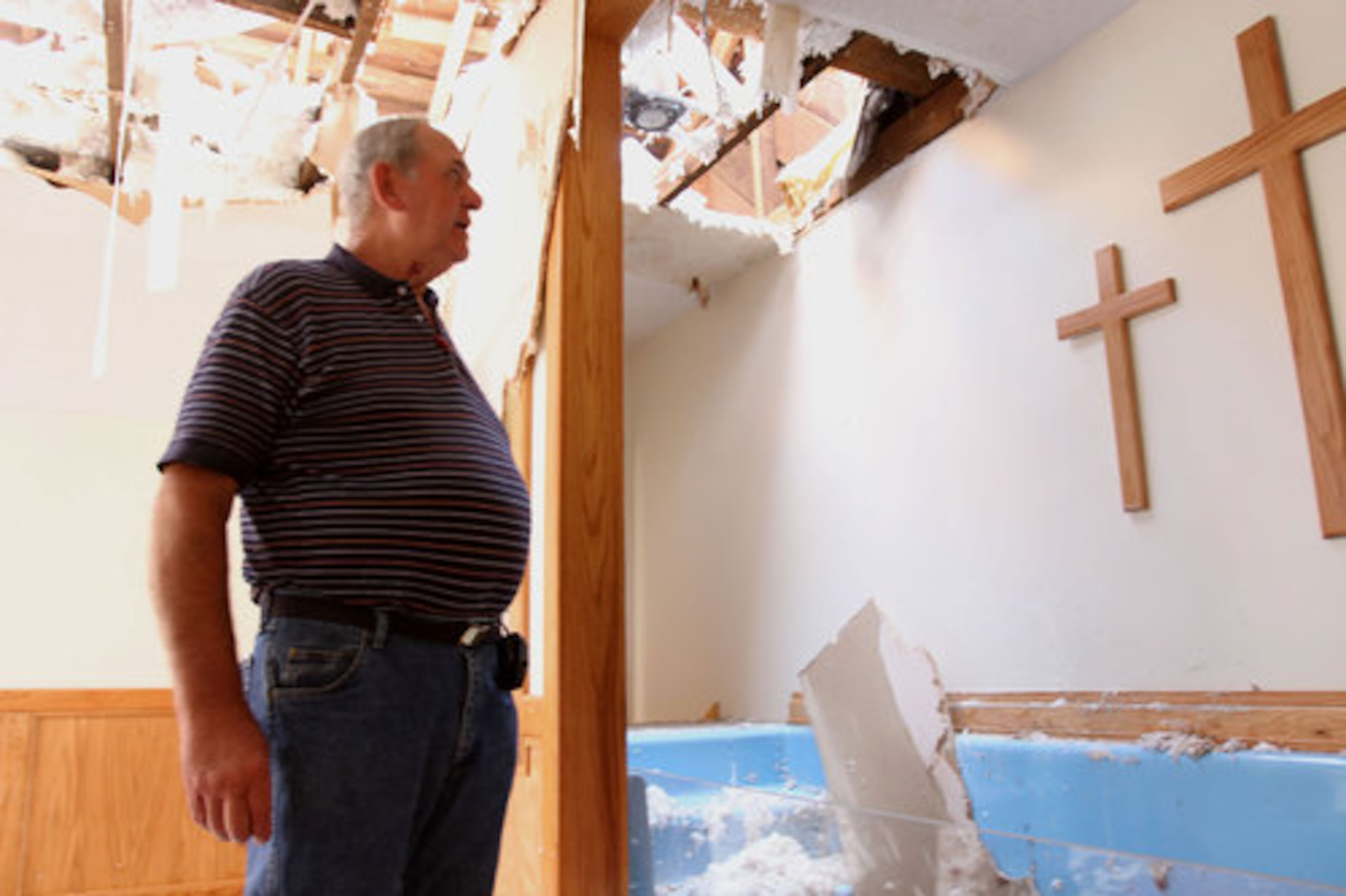 Longtime church member Gene Powell survey the damaged destroyed by last week's twister at Crowe Springs Baptist Church in Cartersville Sunday, May 1, 2011. Powell helps with the remodeling of the church before the destruction and said the entire building will have to be torn down and rebuilt from scratch. The church of about 100 members held their Sunday service at the church parking lot.