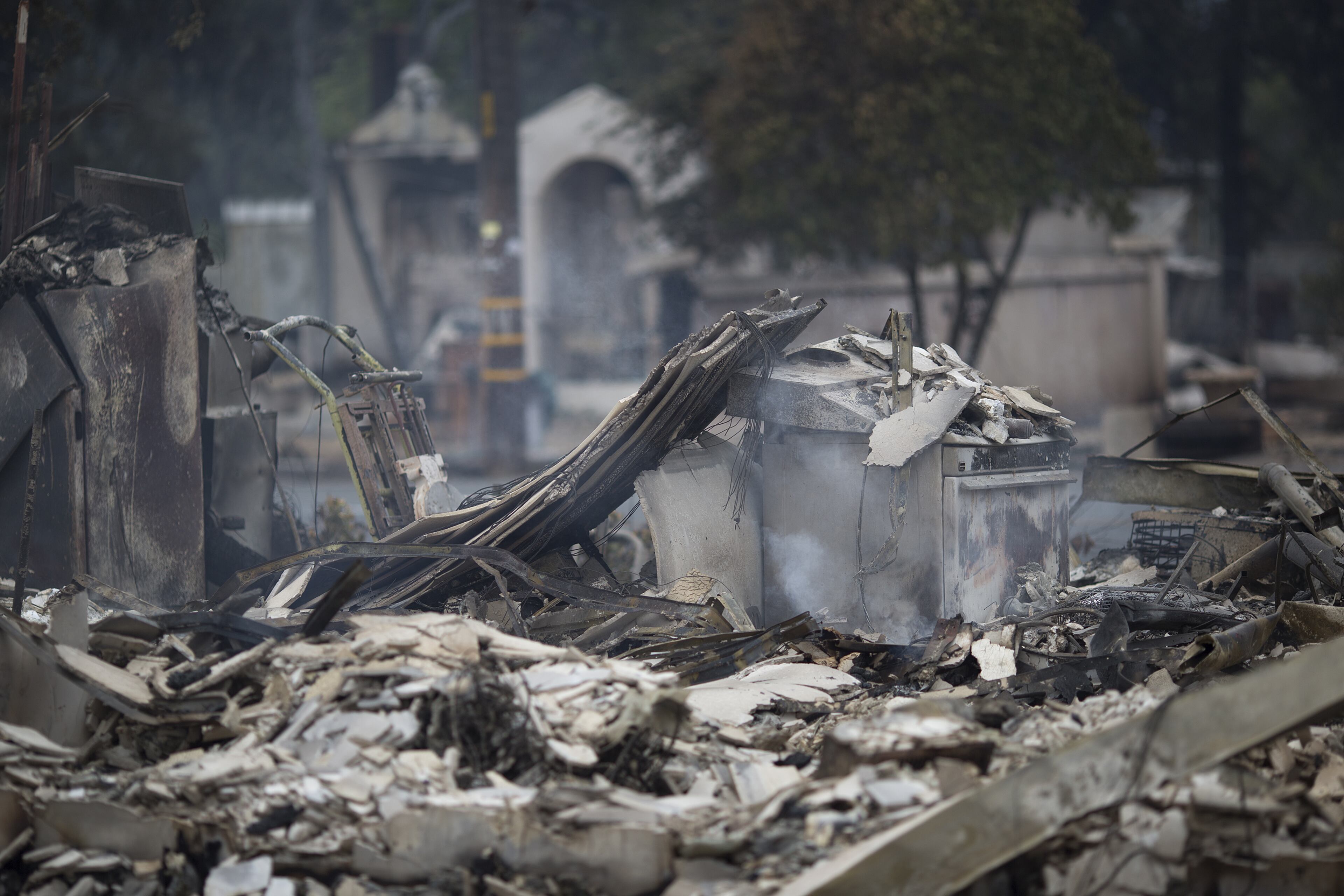 An apartment complex and a house, in the distance, lies in ruins, burned by the Valley Fire, on September 14, 2015 in Middletown, California. The 95-square-mile fire has destroyed hundreds of homes and is only five percent contained. (Photo by David McNew/Getty Images)
