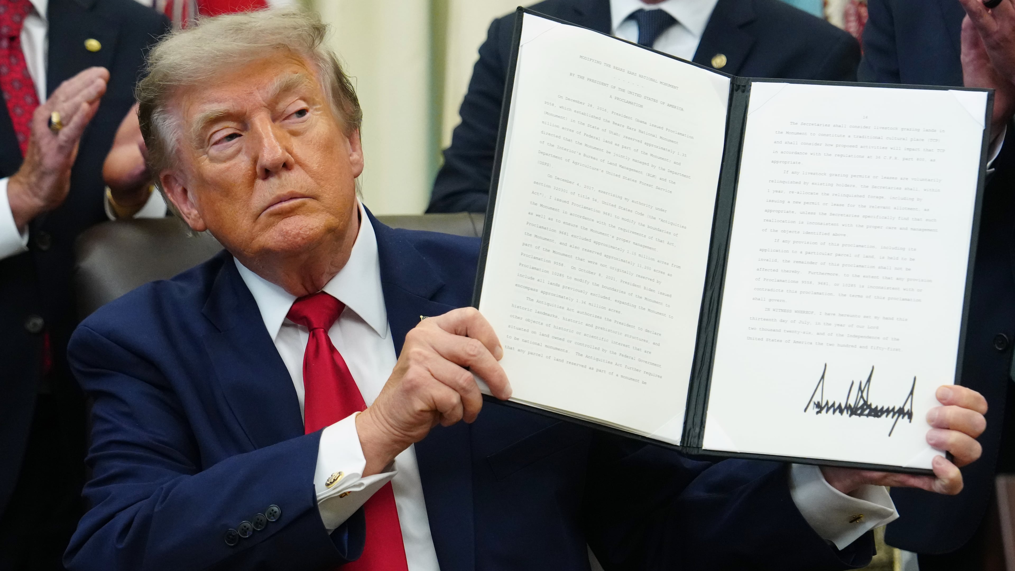 President Donald Trump holds a signed executive order modifying the Bears Ears National Monument in the Oval Office of the White House, Monday, July 13, 2026, in Washington. (AP Photo/Julia Demaree Nikhinson)
