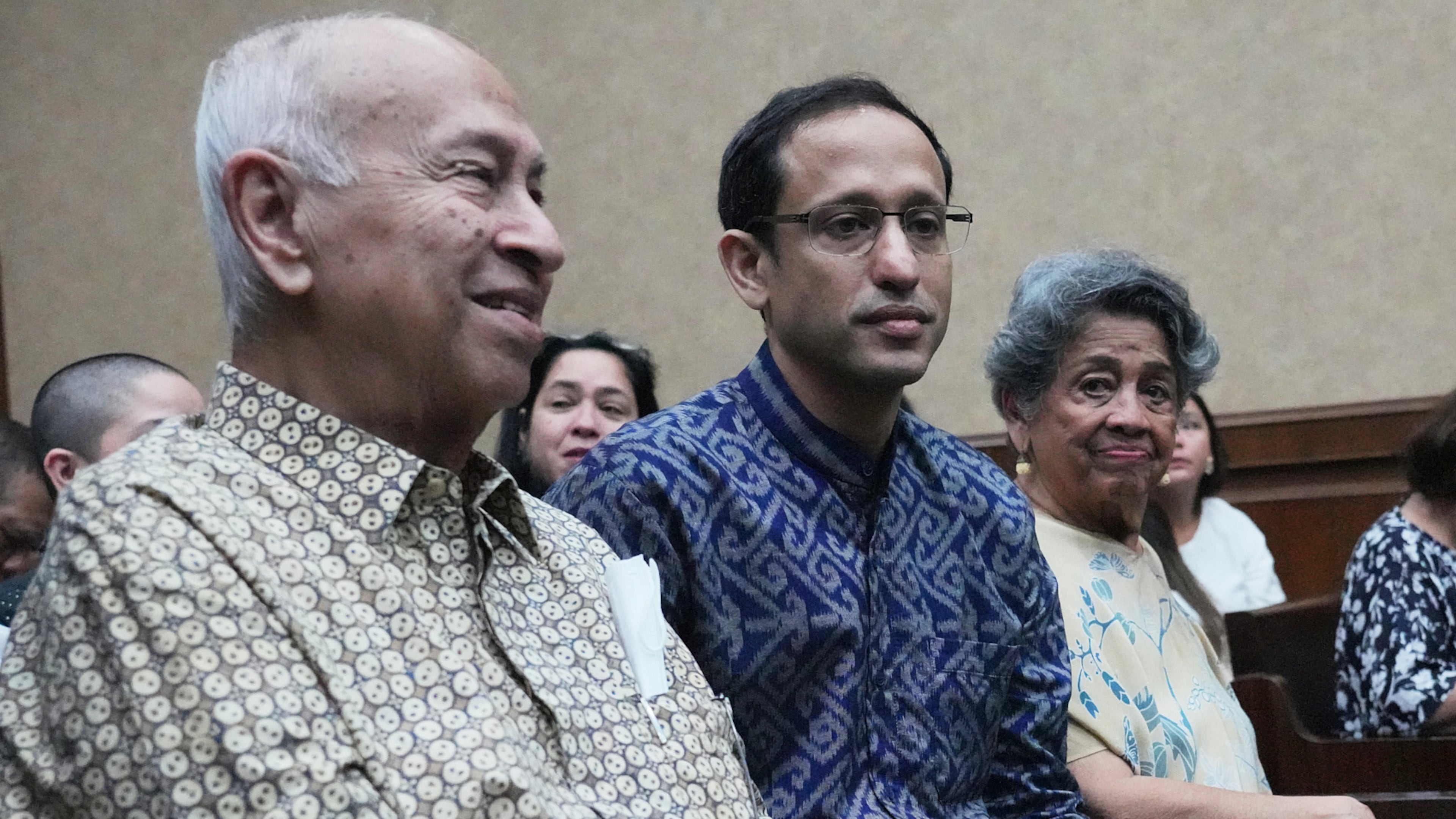 Nadiem Anwar Makarim, former Education Minister and the co-founder of Indonesia's payments platform and ride hailing company Gojek, center, who is accused of corruption in a government project to procure school laptops, is flanked by his parents Nono Anwar Makarim, left, and Atika Algadrie before the start of his trial hearing at the Corruption Court in Jakarta, Indonesia, Monday, April 20, 2026. (AP Photo/Achmad Ibrahim)