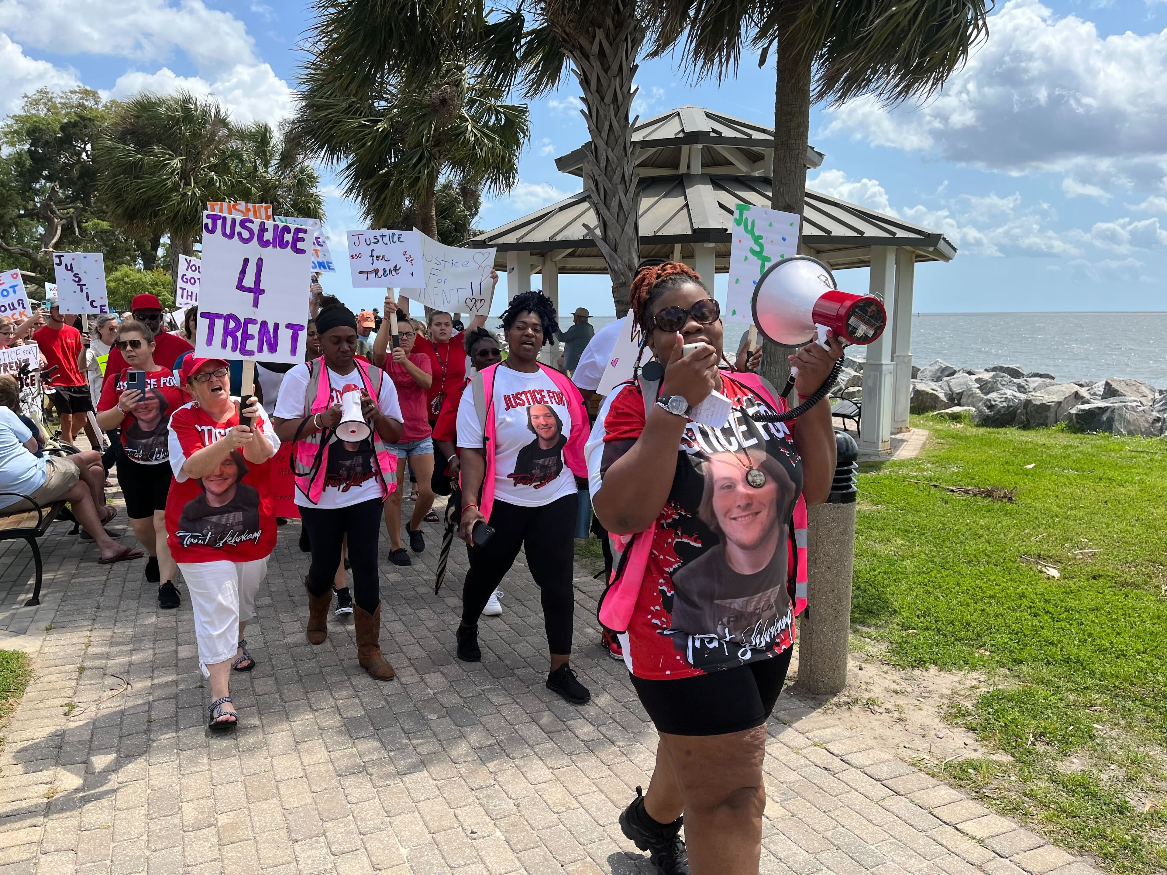 Thea Brooks leads a march with a megaphone in hand during the rally for 19-year-old Trent Lehrkamp on St. Simons Island Saturday afternoon.