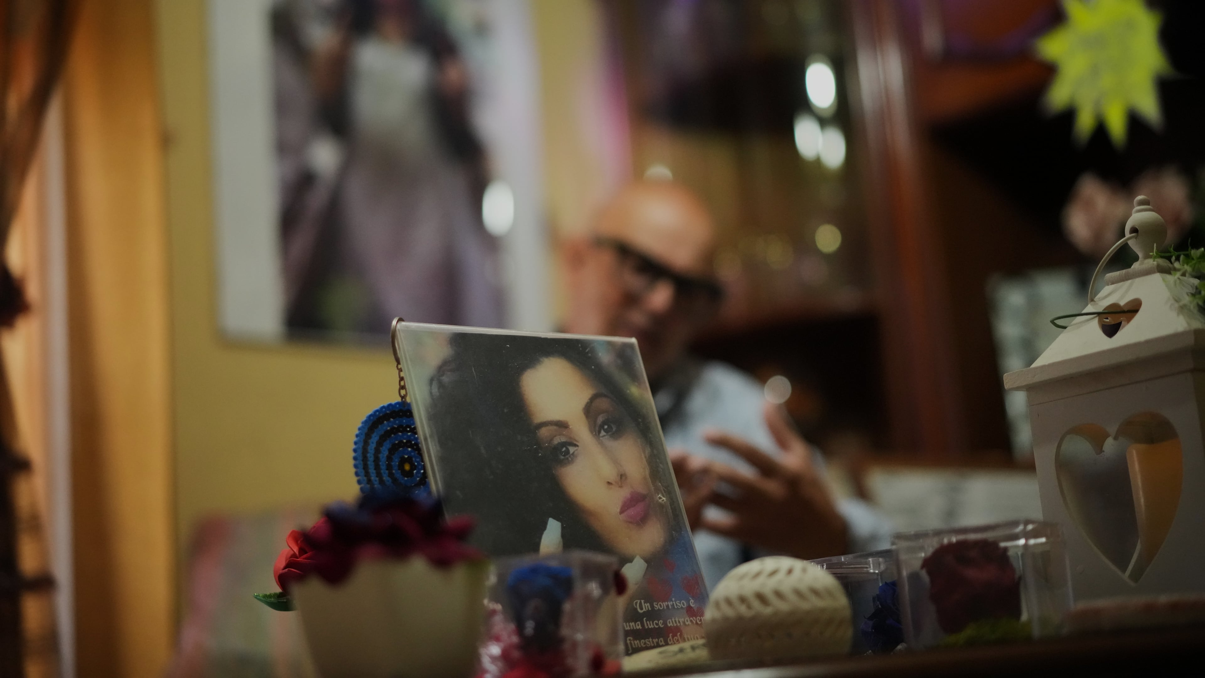 Angelo Venturato talks during an interview with the Associated Press next to photos of his daughter Maria who died at the age of 25 of a cancer he claims to be connected to decades of pollution from illegal waste dumping and burning, much of it linked to organized criminal groups, in the southern town of Acerra, Friday, May 22, 2026. (AP Photo/Andrew Medichini)