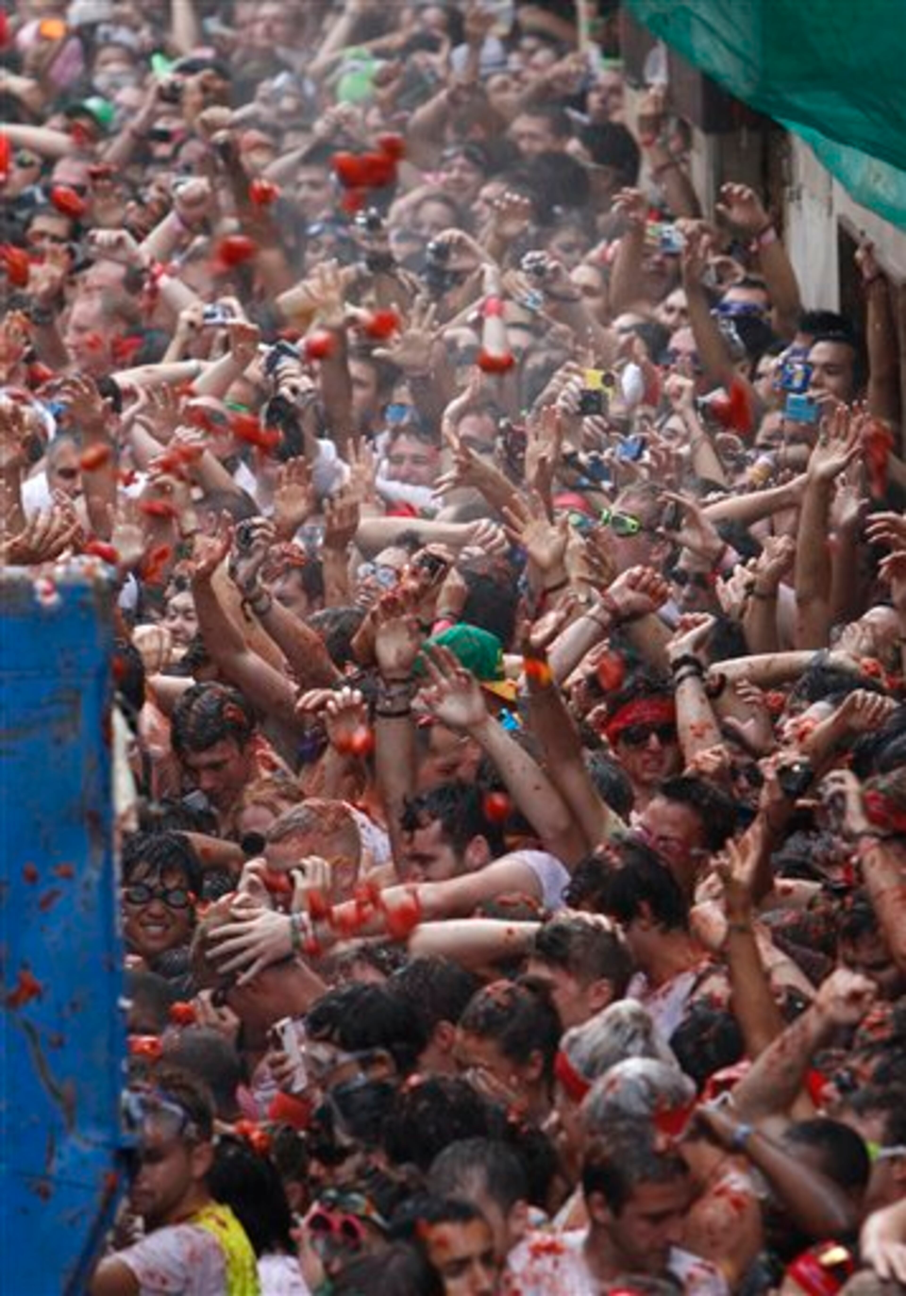 Thousands of people splatter each other with tons of tomatoes in the annual "Tomatina" battle in recession-hit Spain, with the debt-burdened town charging out-of-town participants entry fees this year for the first time. (AP Photo/Alberto Saiz)