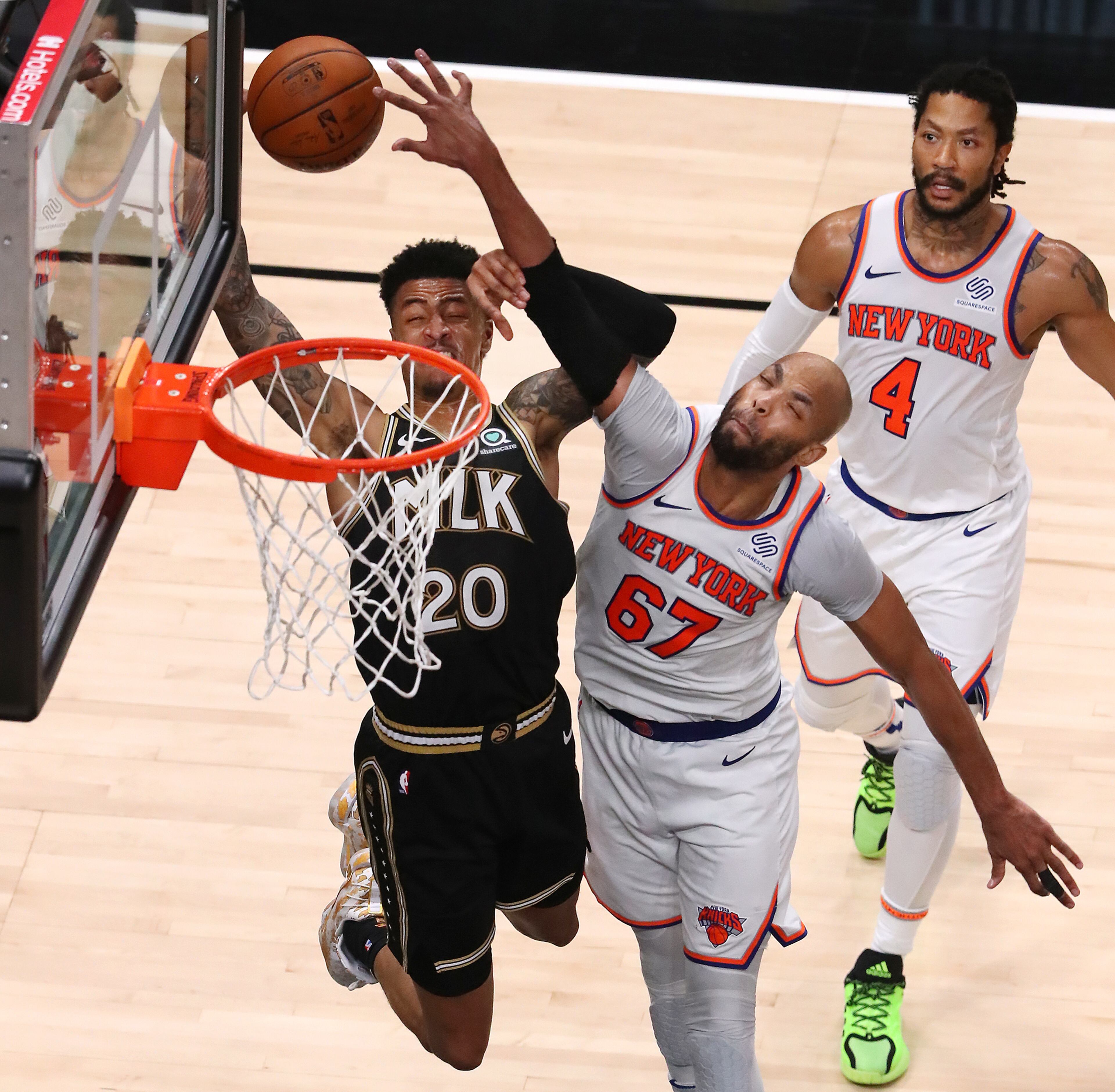 Hawks forward John Collins is fouled on his way to the basket by New York Knicks forward Taj Gibson with Derrick Rose (4) trailing the play during Game 4 of their first-round NBA playoff matchup Sunday, May 30, 2021, at State Farm Arena in Atlanta. (Curtis Compton / Curtis.Compton@ajc.com)