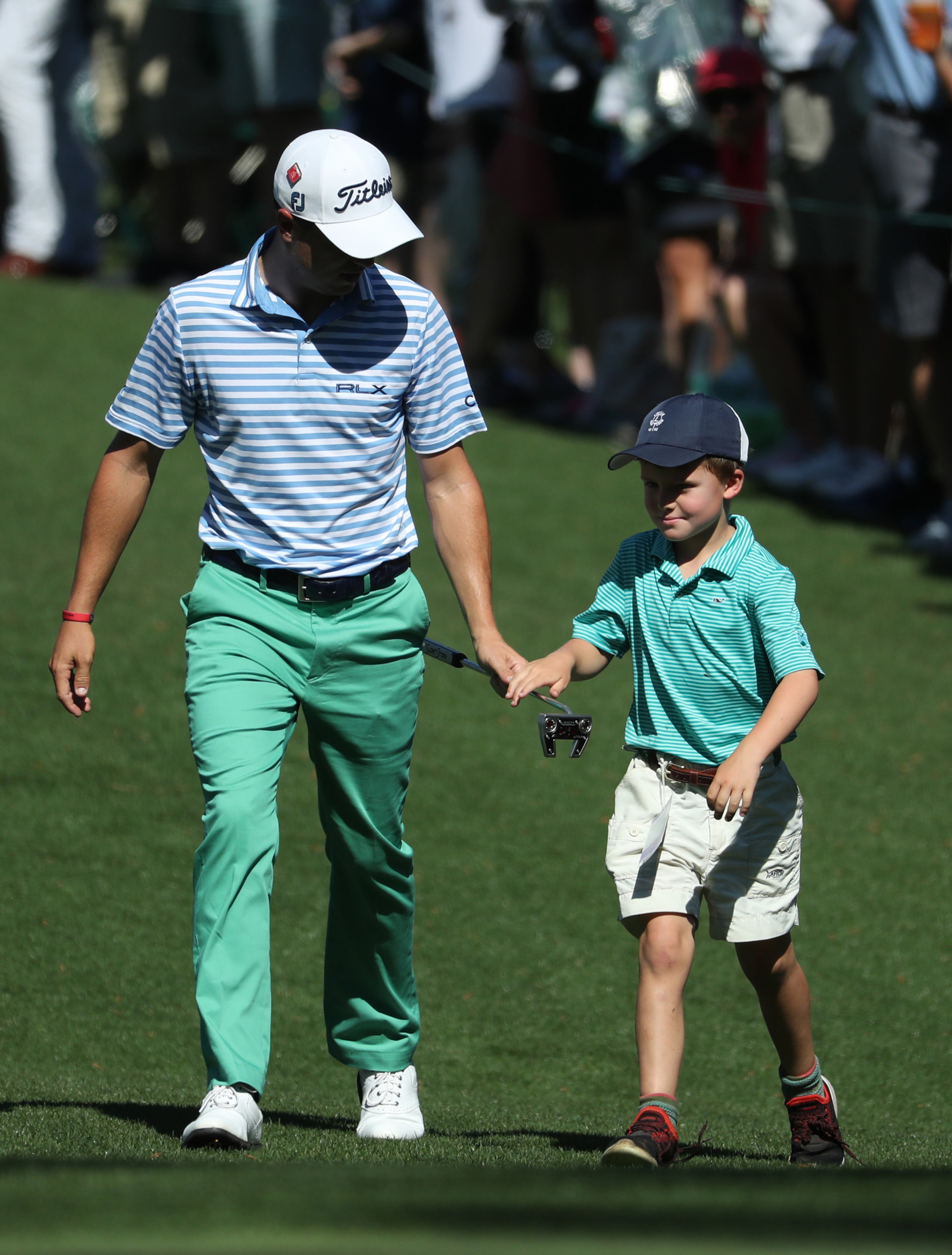 April 10, 2019 - Augusta, Ga: Justin Thomas brings in a boy from the crowd to putt on the seventh hole during the Masters' Par 3 Contest Wednesday, April 10, 2019, at Augusta National Golf Club in Augusta. (JASON GETZ/SPECIAL TO THE AJC)