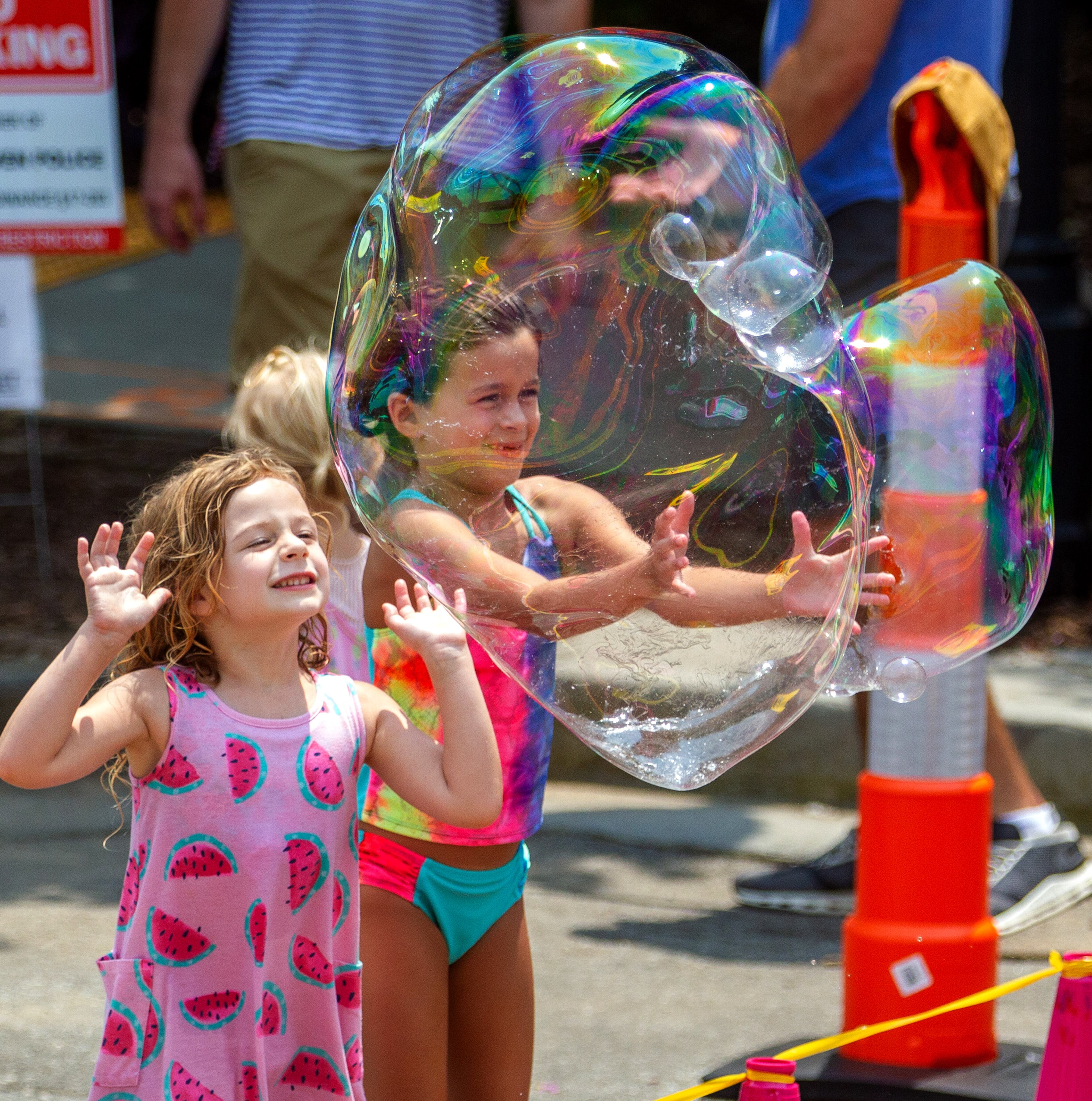 Kids pop large bubbles created by Deborah Mosher during the Brookhaven Cherry Blossom Festival on Saturday, July 31, 2021. STEVE SCHAEFER FOR THE ATLANTA JOURNAL-CONSTITUTION